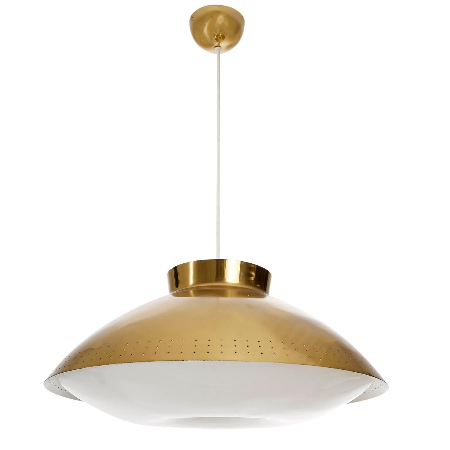 A Scandinavian Modern white plexiglass and brass pendant light designed by Lisa Johansson-Pape for Orno, manufactured in midcentury, circa 1950.
The fixture is made of a round and perforated brass lamp shade which is white painted on the inner