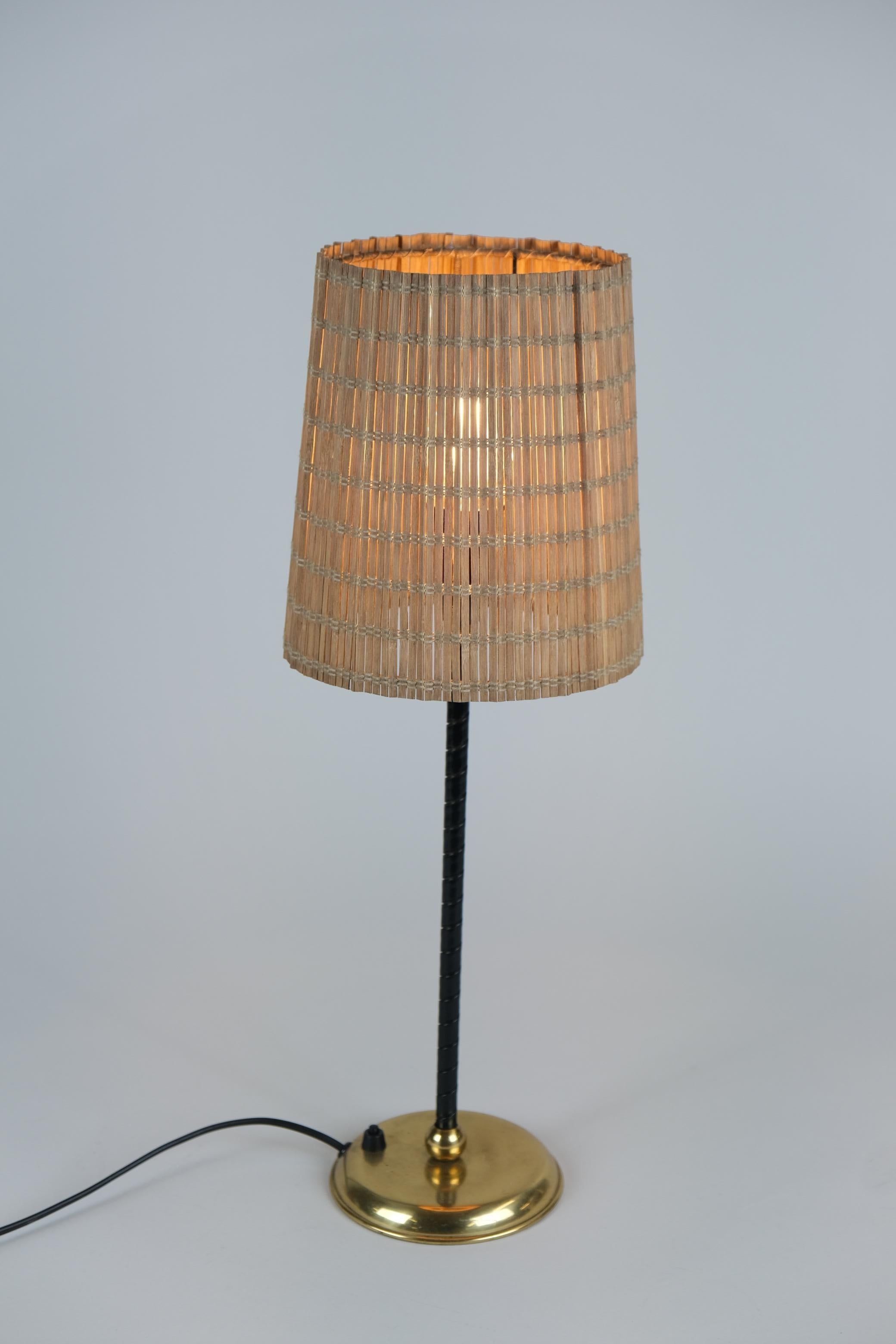 Rara lámpara de sobremesa moderna de mediados de siglo, de principios de los años 50, diseñada por Lisa Johansson-Pape y fabricada por Orno en Finlandia. Este esbelto modelo es bastante elegante y tiene una base de latón con una envoltura de