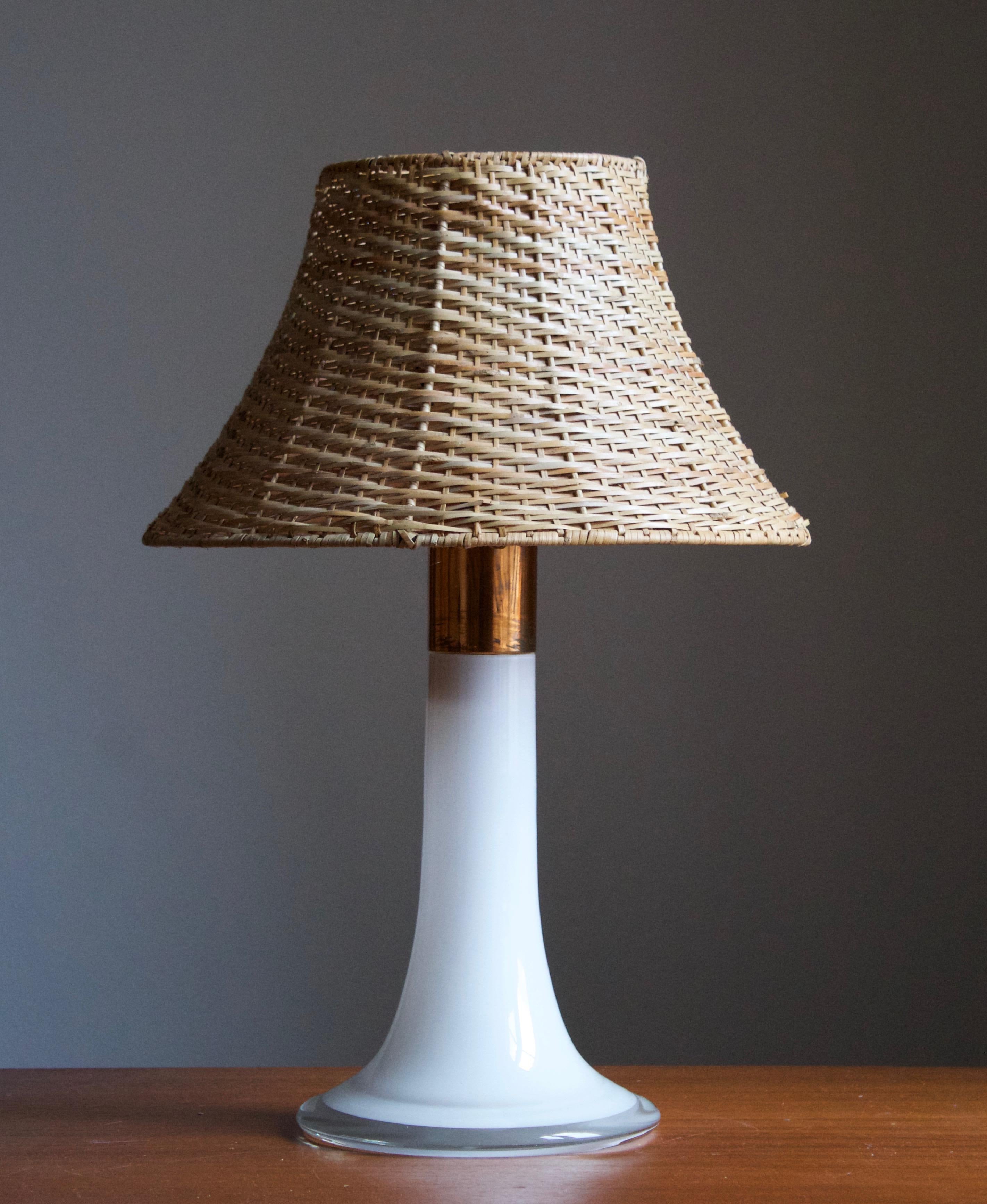 A table lamp, designed by Lisa Johansson-Pape in 1954. Produced in the 1960s by Oy Stockmann-Ornö AB. Executed in opaque glass and Copper.

Stated measurements excluding lampshade. Upon request assorted vintage rattan lampshade illustrated can be