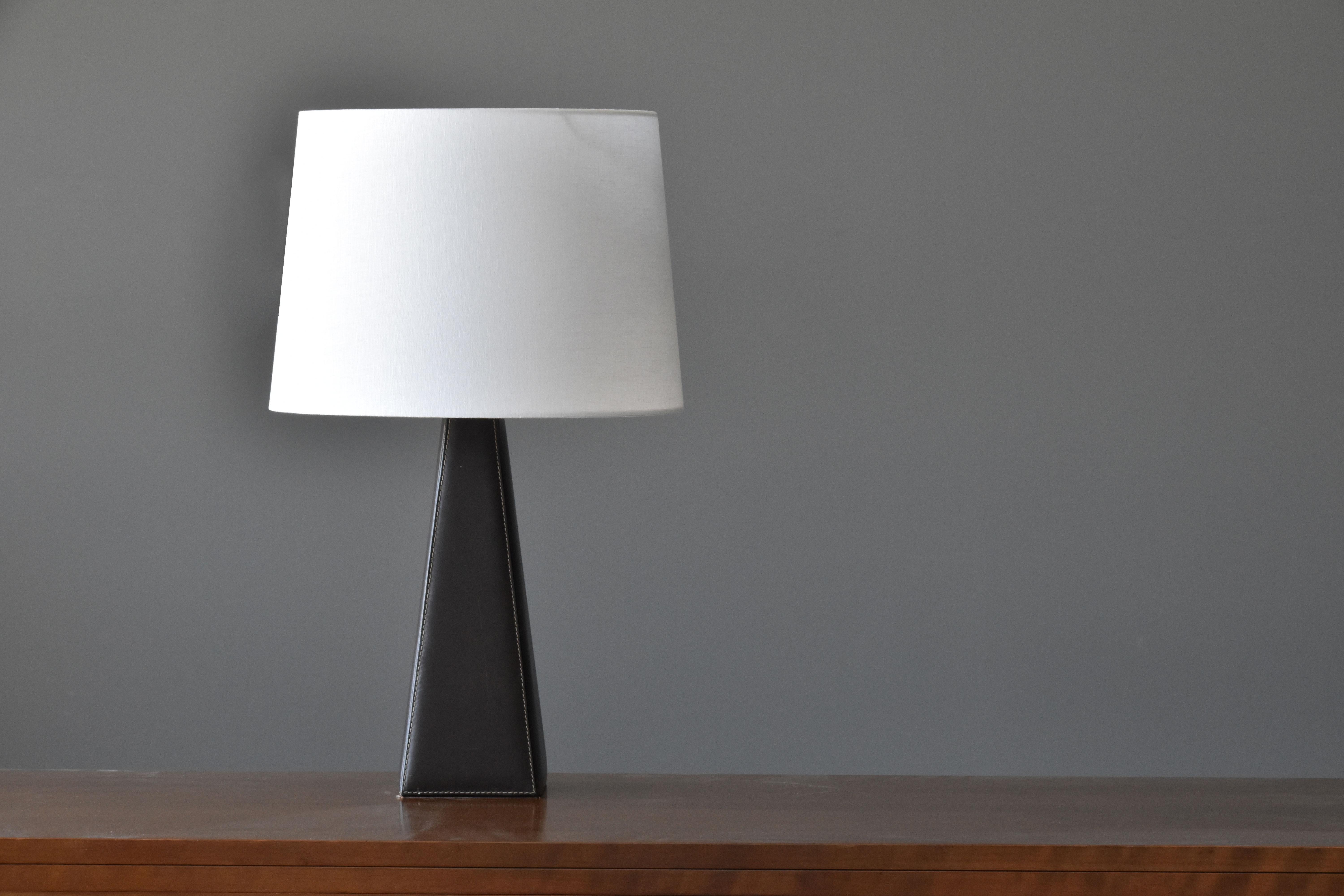 A table lamp designed by Lisa Johansson-Pape. Produced by Ornö, Finland in the 1960s. 

Made of a solid block of wood covered in leather, fitted with a brass neck. Sold without lampshade. 

Other contemporary Scandinavian lighting designers include