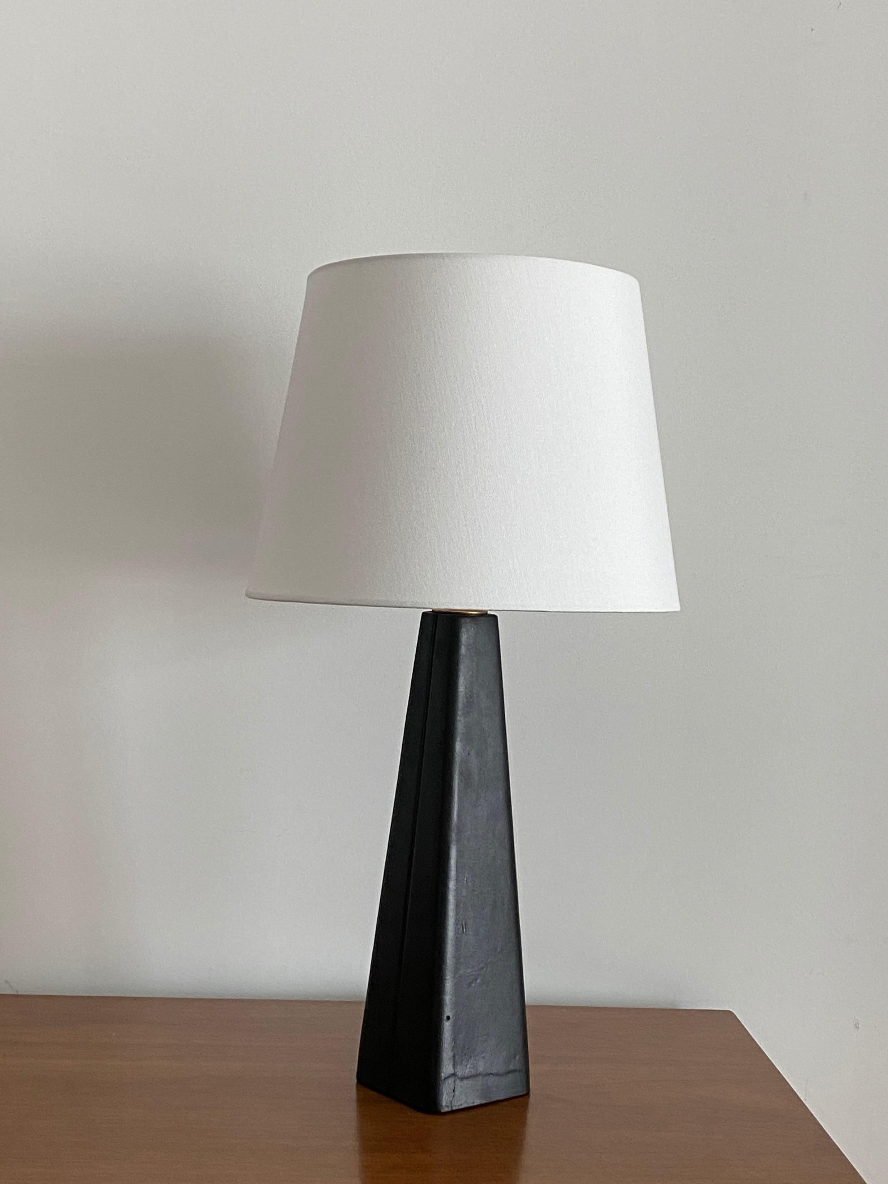 A table lamp designed by Lisa Johansson-Pape. Produced by Ornö, Finland in the 1960s. 

Made of a solid block of wood covered in leather, fitted with a brass neck. Lampshade attached for illustration. Sold without lampshade. Measured without
