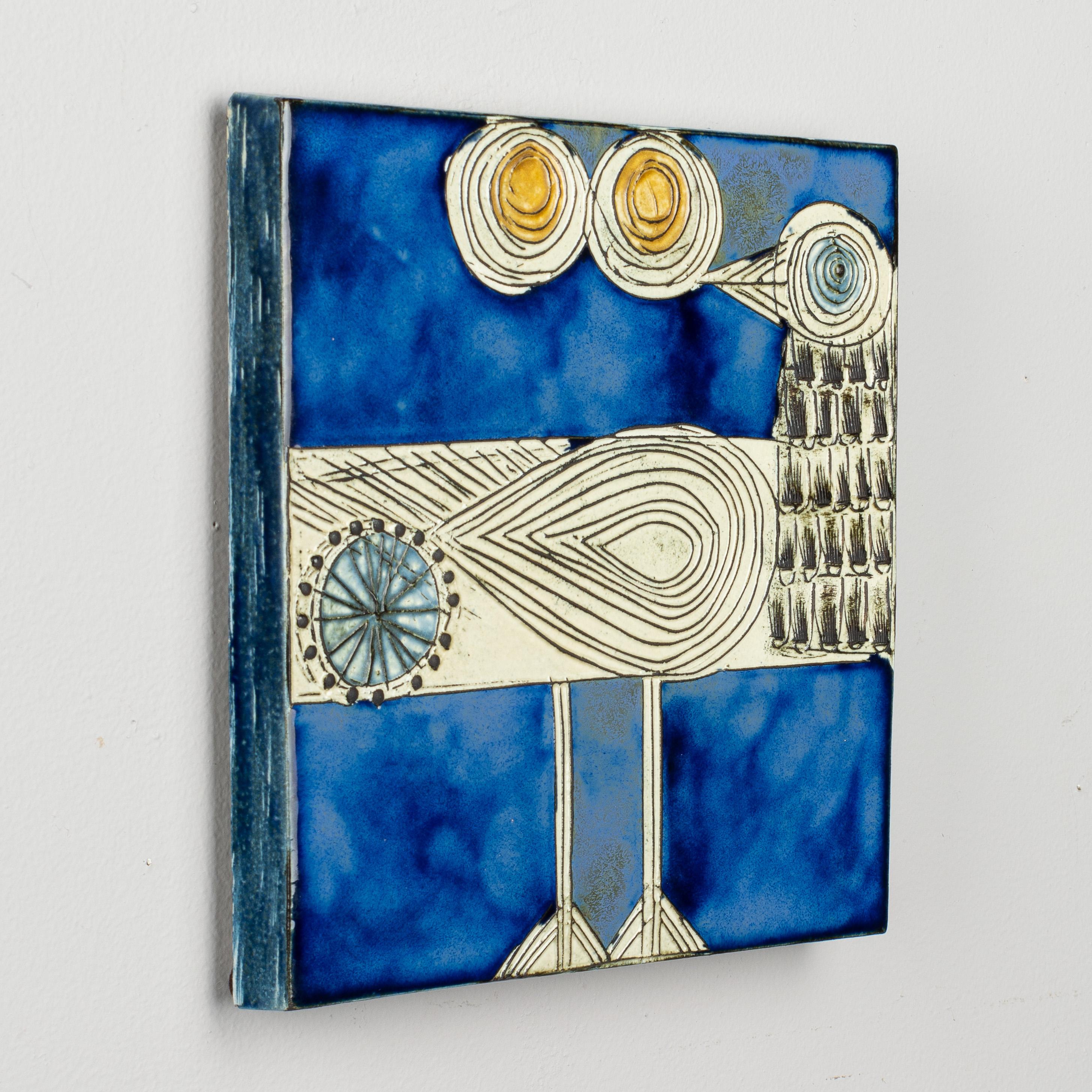 A Swedish Mid-Century Modern Lisa Larson sandpiper (drillsnäppa) wall plaque. Handcrafted glazed stoneware ceramic relief with stylized bird against a bold blue colored background. Designed in 1966 as part of the Wall Plaques (Vaggplattor) series