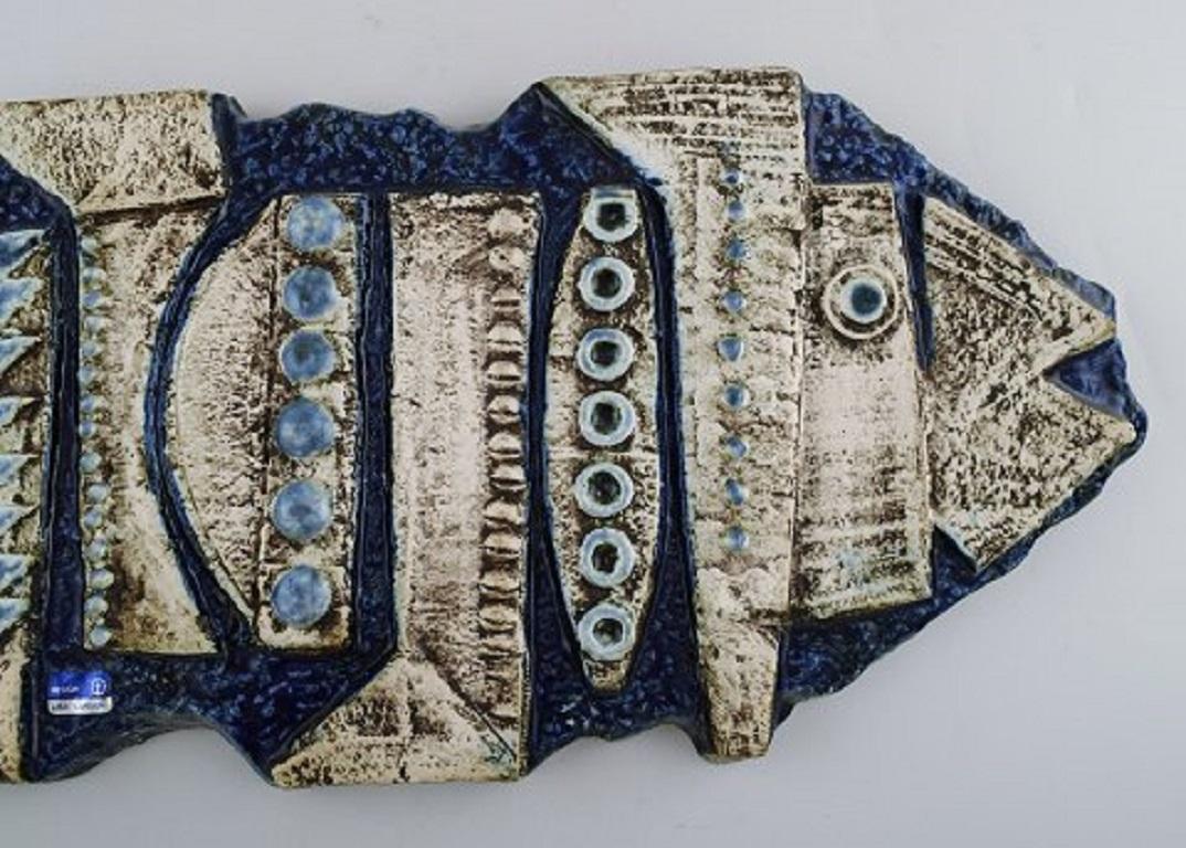 Lisa Larson for Gustavsberg. Colossal and rare wall plaque in glazed ceramics shaped as a fish.
1960s.
Measures: 55 x 21 cm.
In very good condition.
Stamped.
Numbered.