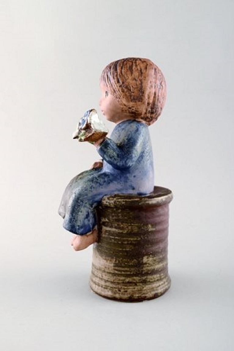 Lisa Larson für Gustavsberg. Mädchen mit Blumen aus glasierter Keramik, 20. Jahrhundert.
Maße: 23 x 11 cm.
In sehr gutem Zustand.
Gestempelt.



   