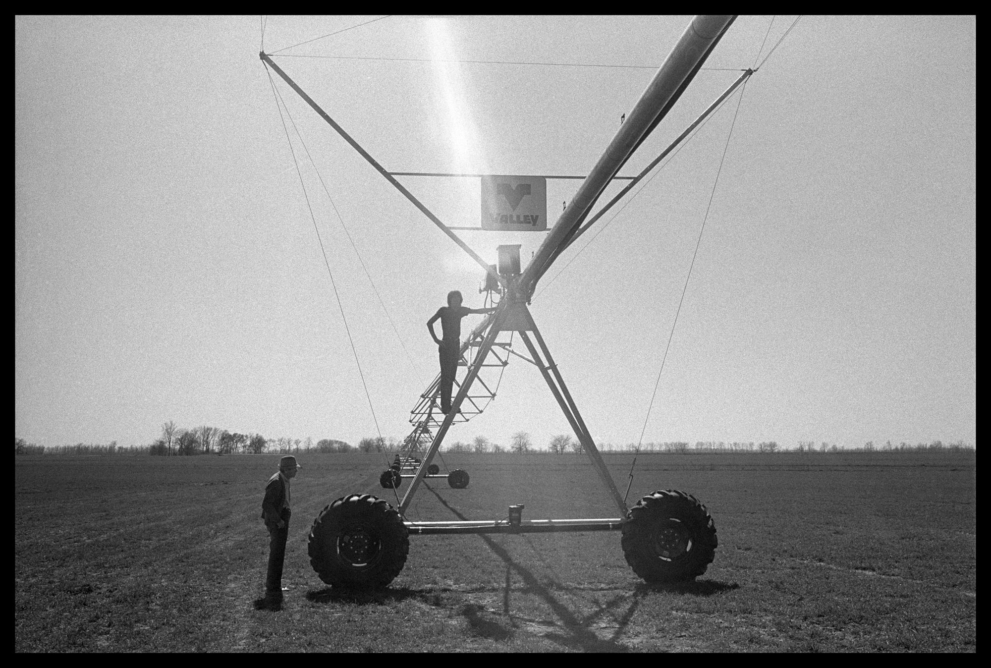 Lisa McCord Figurative Photograph - Granddaddy and Lind with Irrigation System