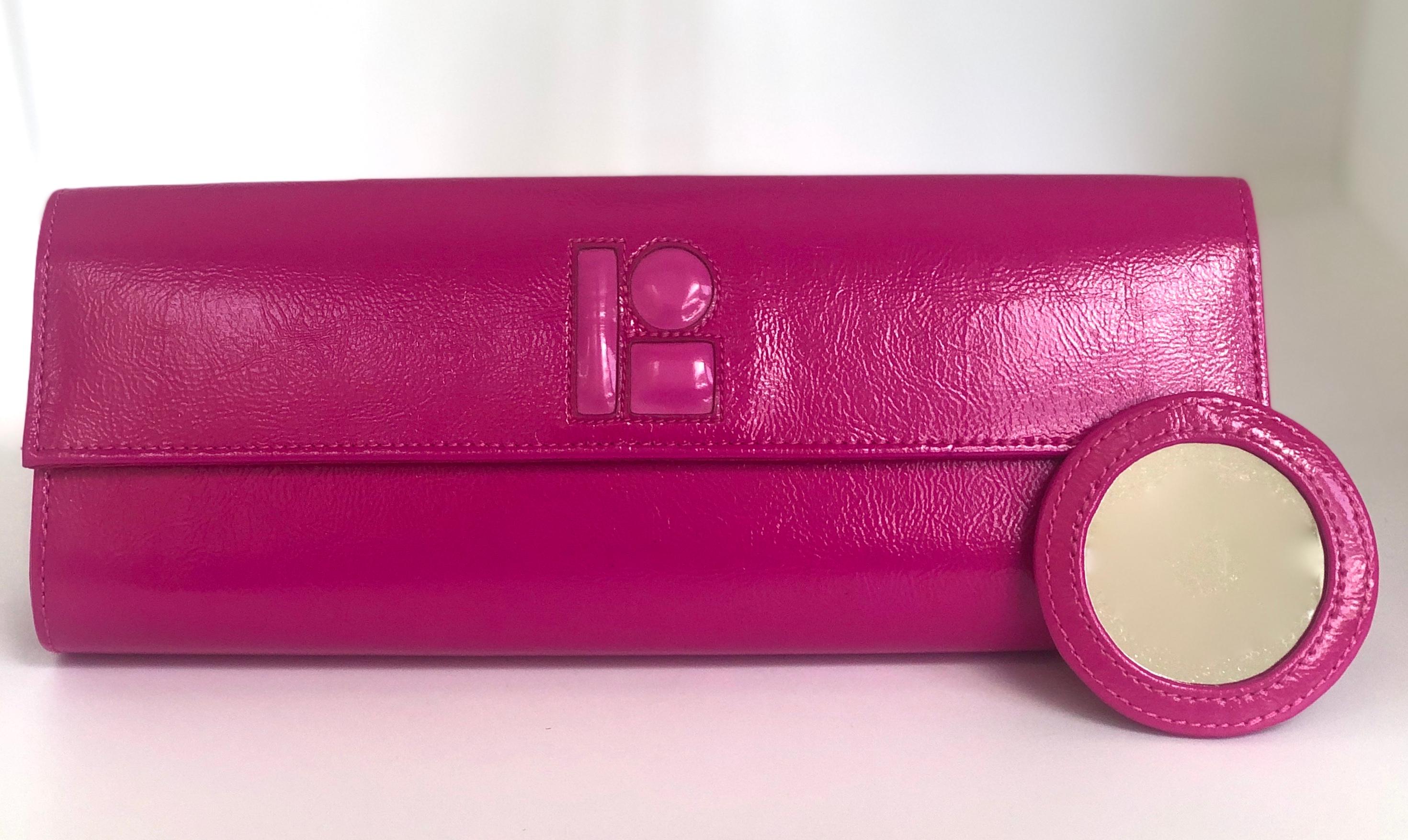 Offered is a signed Lisa Perry fuchsia pink patent leather clutch with magnetic closure and matching removable compact fuchsia patent leather backed compact mirror.  Lisa Perry is the wife of the hedge fund guru and former owner of Barney's New
