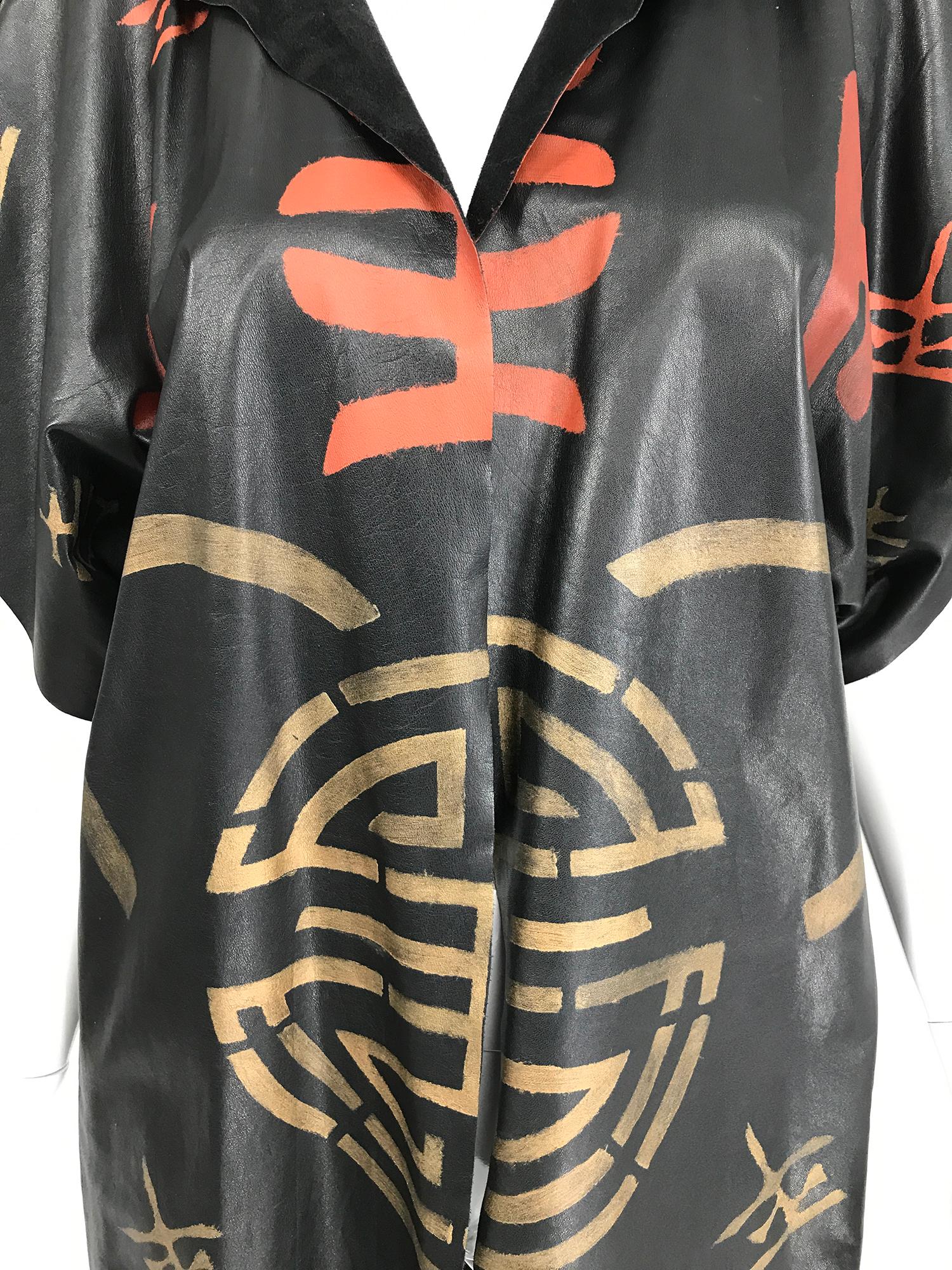 Lisandro Sarasola hand painted leather jacket from the 1980s. Black leather is painted in red and gold symbols front and back. Cap sleeves, open front without closures. Unlined. There is a single leather button on the left shoulder, for keeping your