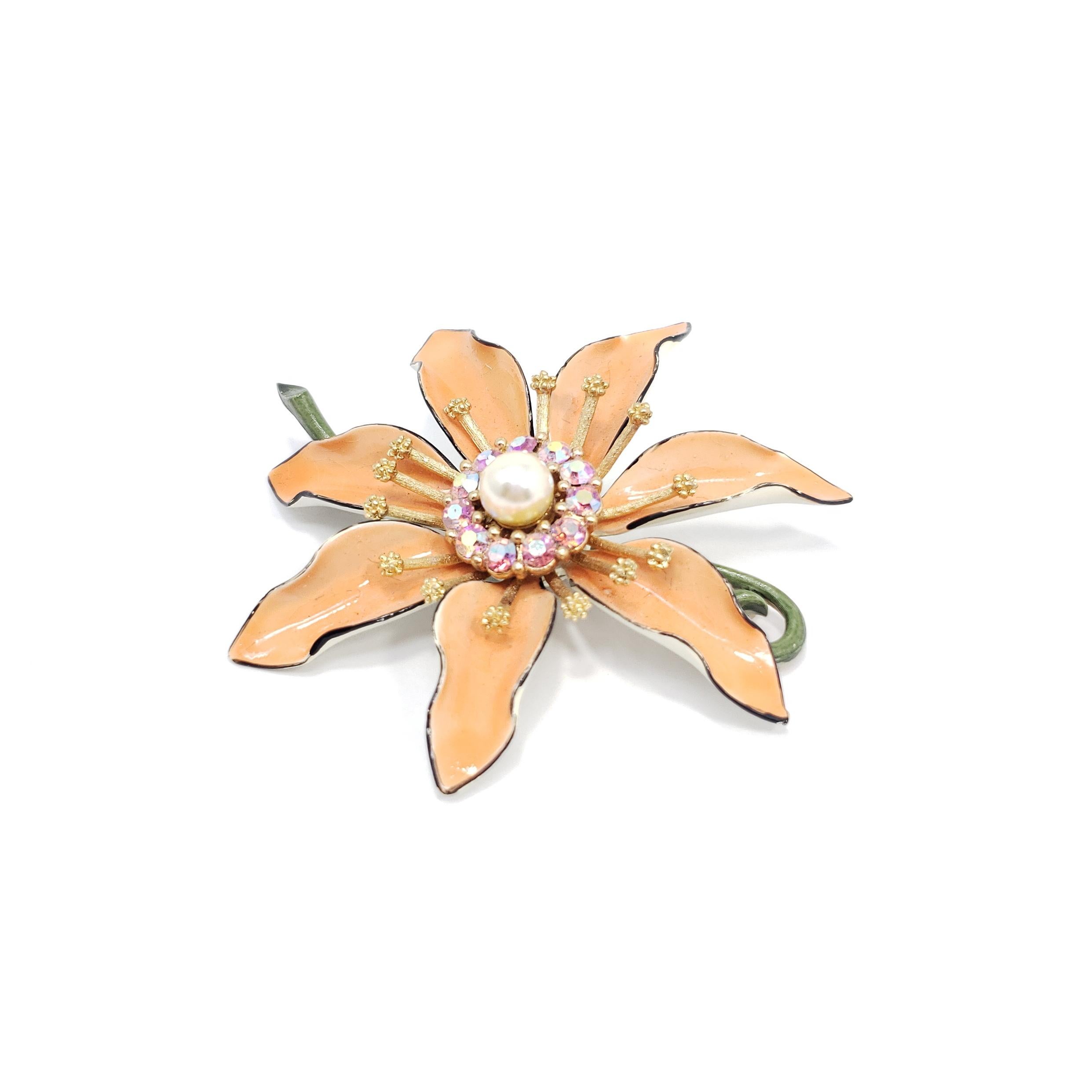 This Lisner flower pin brooch is painted with pastel orange, green, and black enamel, and is accented with rose aurora borealis crystals and a single faux pearl. A classy addition to any ensemble!

Marks / hallmarks / etc: Lisner

Gold-plated