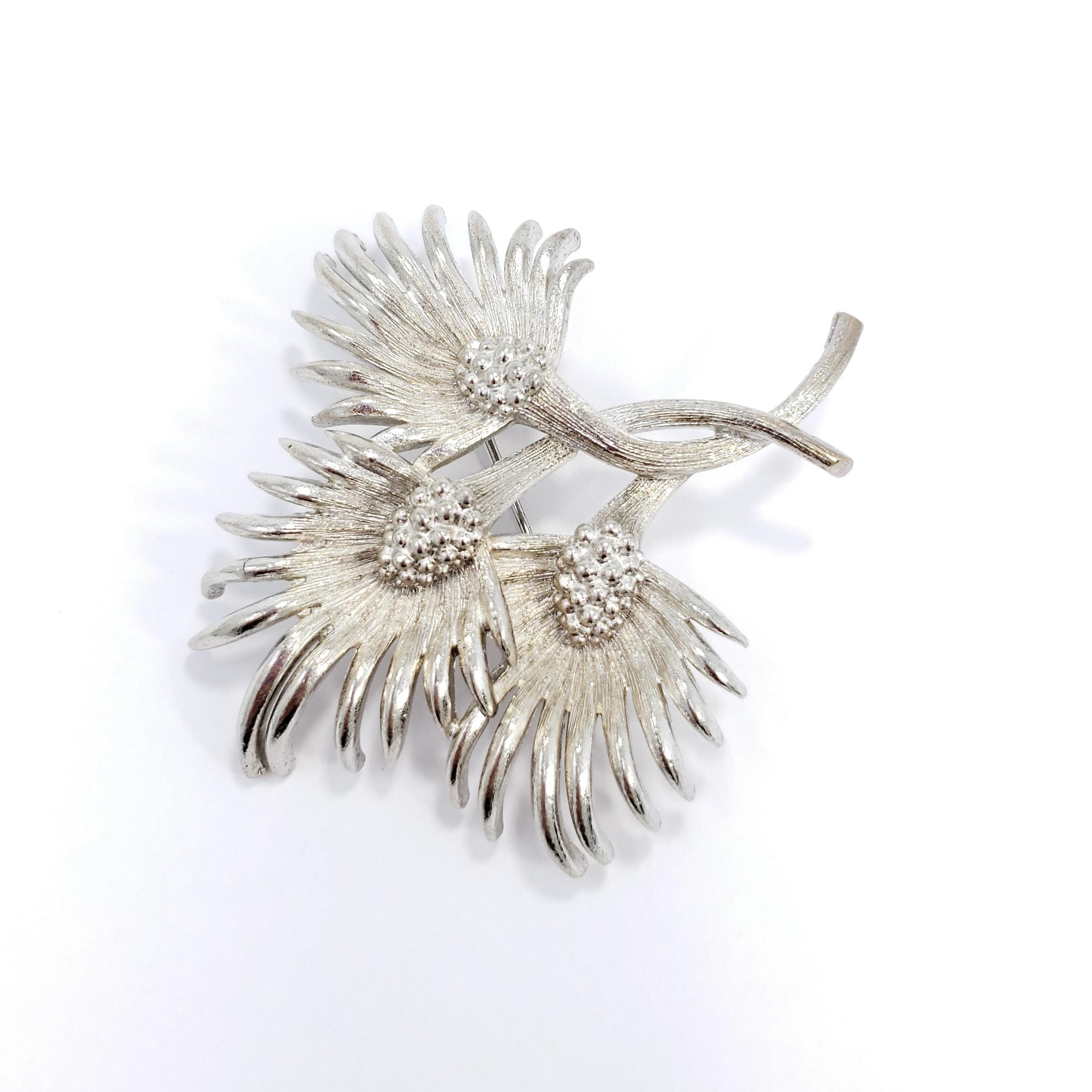 A stylish pin brooch by Lisner, featuring three flowers in silver tone.

Hallmarks: Lisner