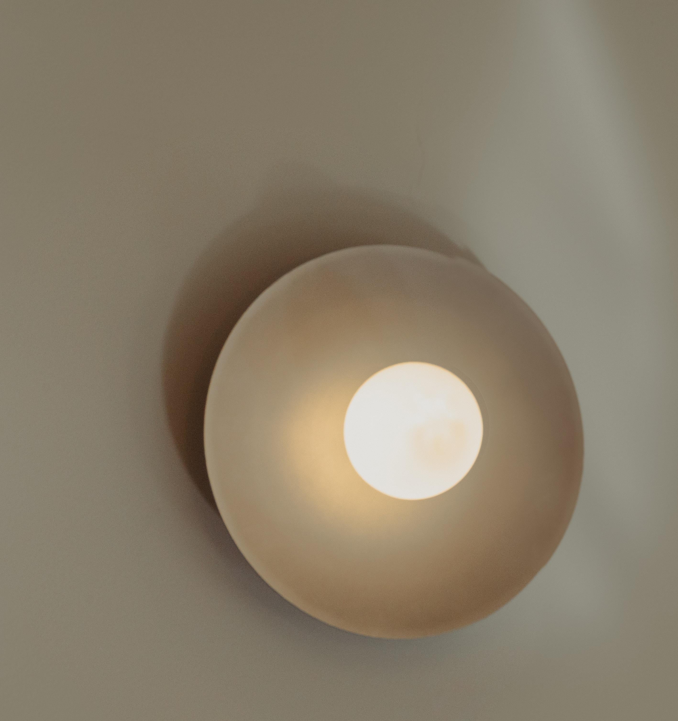 Lita Wall-Mounted Fixed Light in Brushed Brass with Opal Glass by Nuumbra
Dimensions: Ø 40 x H 40 cm. 
Materials: Brushed brass and opaline glass.

Available in brushed or aged brass, and blackened or brushed aluminum. Prices may vary. All our lamps