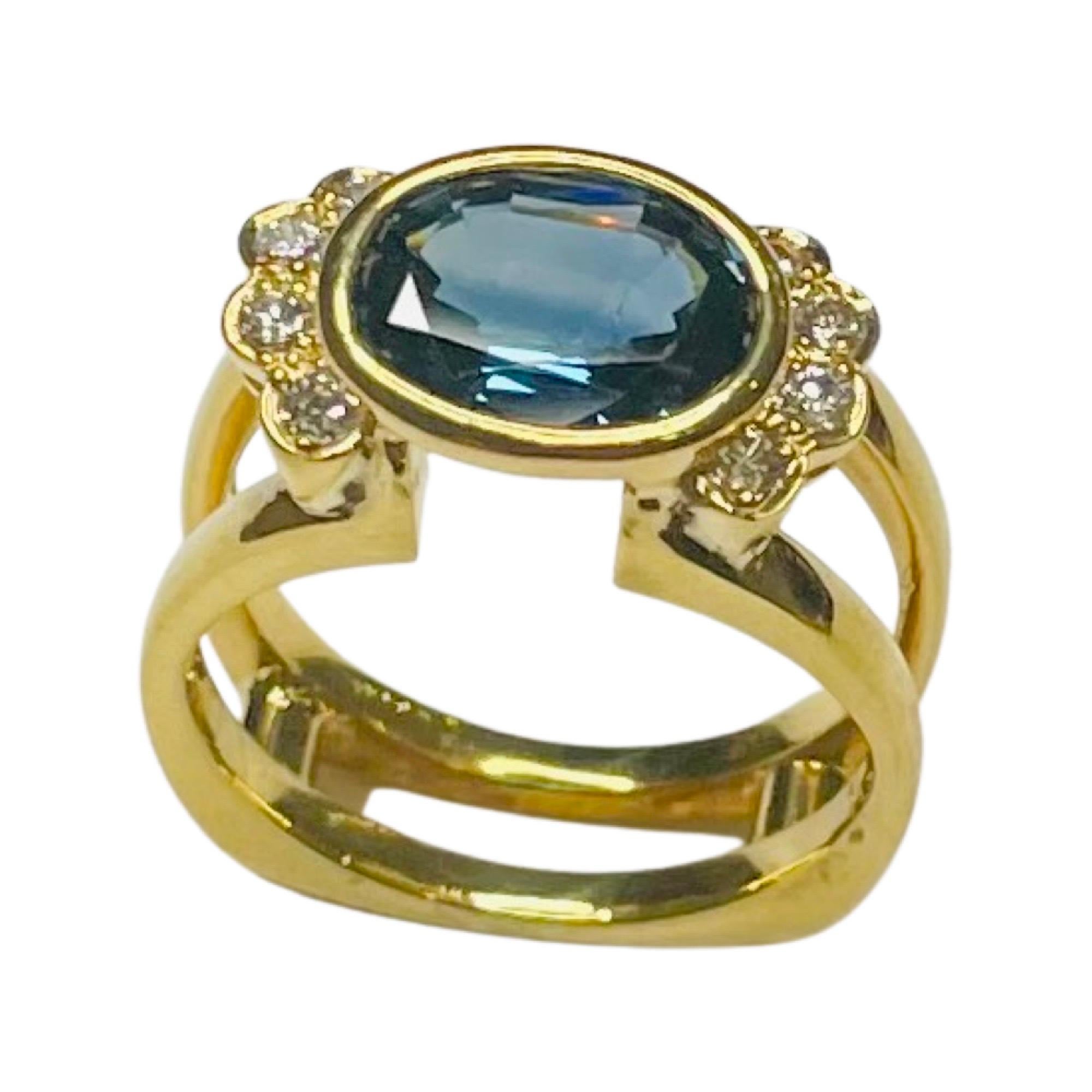 Lithos 18K Yellow Gold Natural Sapphire and Diamond Ring. The sapphire is natural and weighs 3.39 carats.  It measures 10.55 mm X 8.2 mm X 4.5 mm. The sapphire is moderately strong, medium dark, violetish blue in color. It is SI1 in Clarity. It is