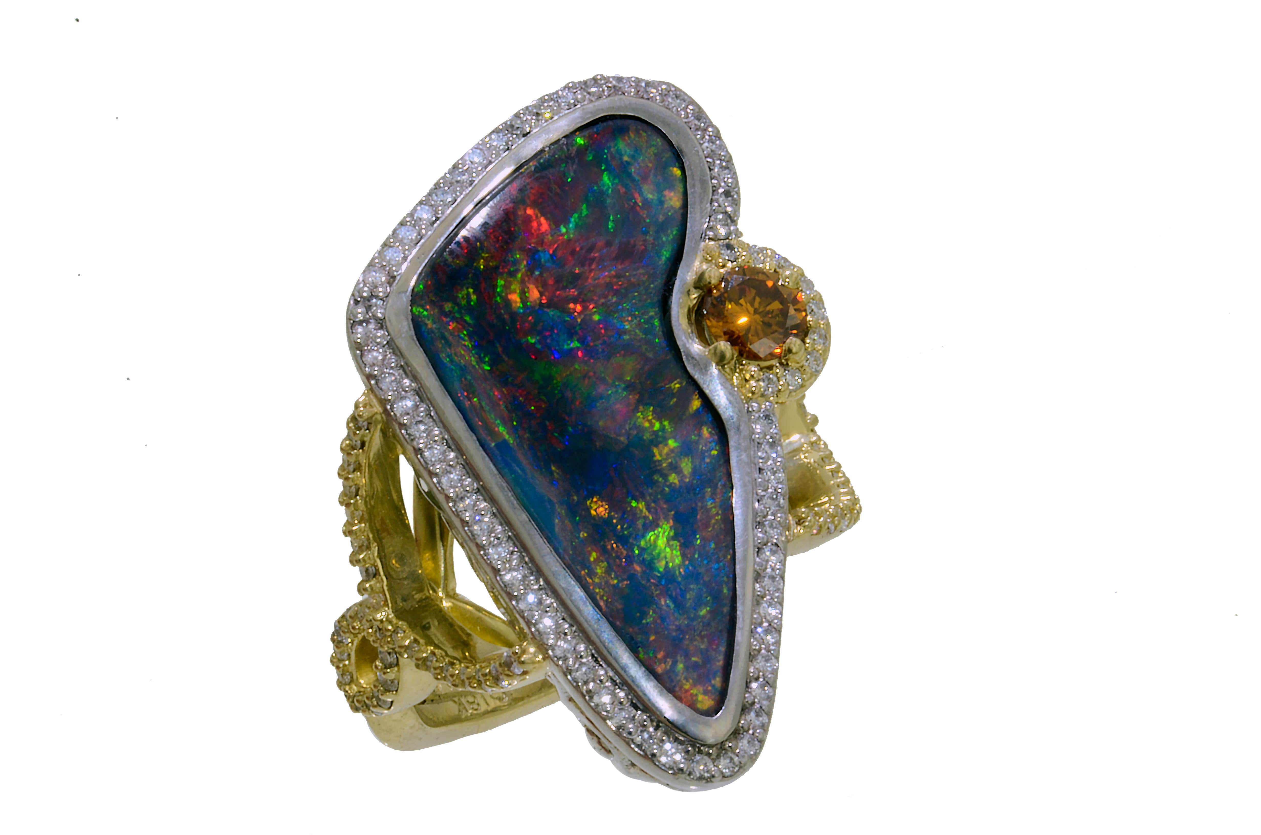 Lithos 18K Yellow Gold, Platinum, Lightning Ridge Opal, Diamond Ring. The natural black opal is from Lightning Ridge Australia. It weighs 9.51 carats. The opal is free formed. It has red, blue and green predominate pin fire. The opal measures 16.18