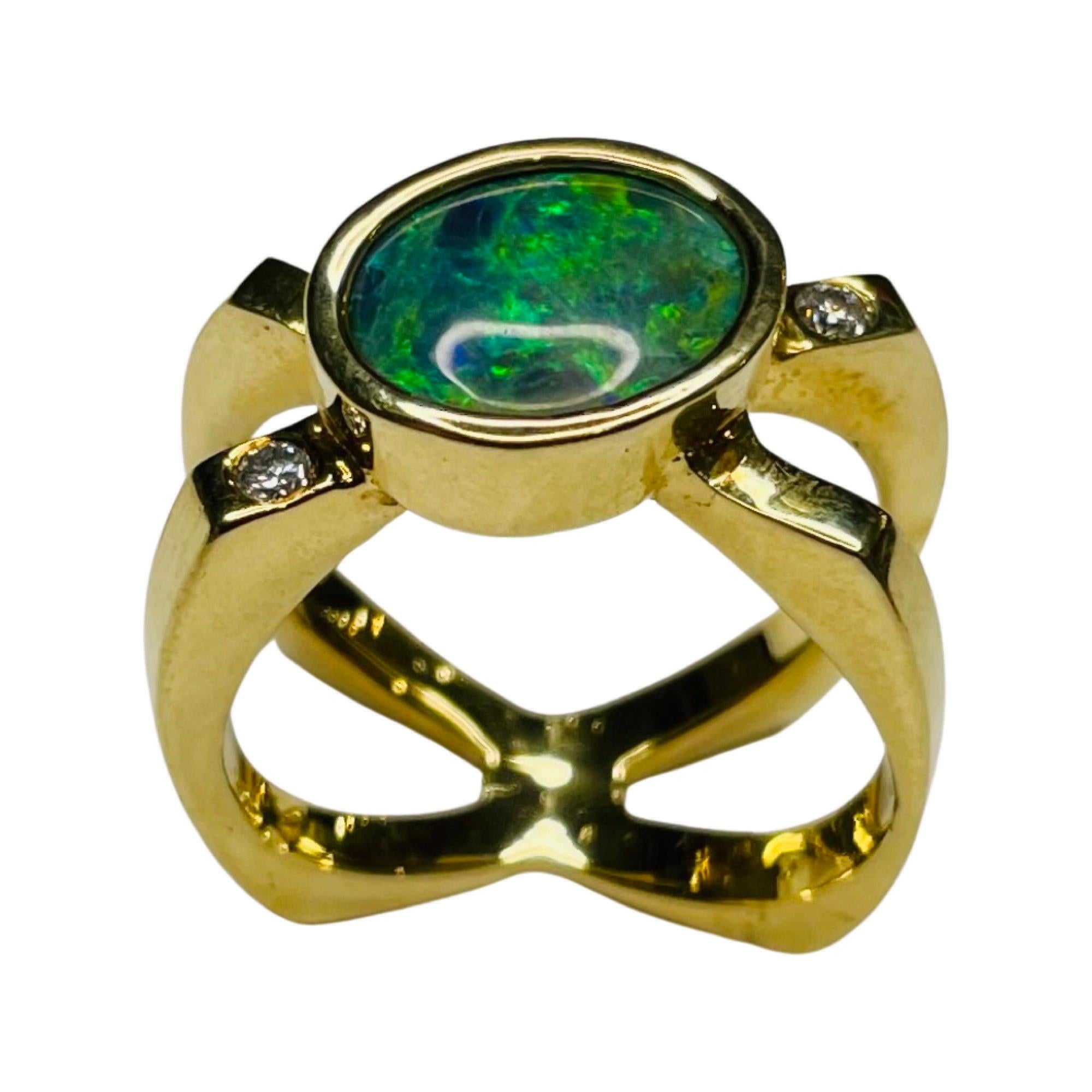 Lithos 18K Yellow Gold Natural Black Opal Ring.  The ring has 4 full cut round brilliant diamonds.  There is a total carat weight of  0.08 carats.  They are of VS clarity and G color. The diamonds are burnish set. The bezel set black opal is 2.75