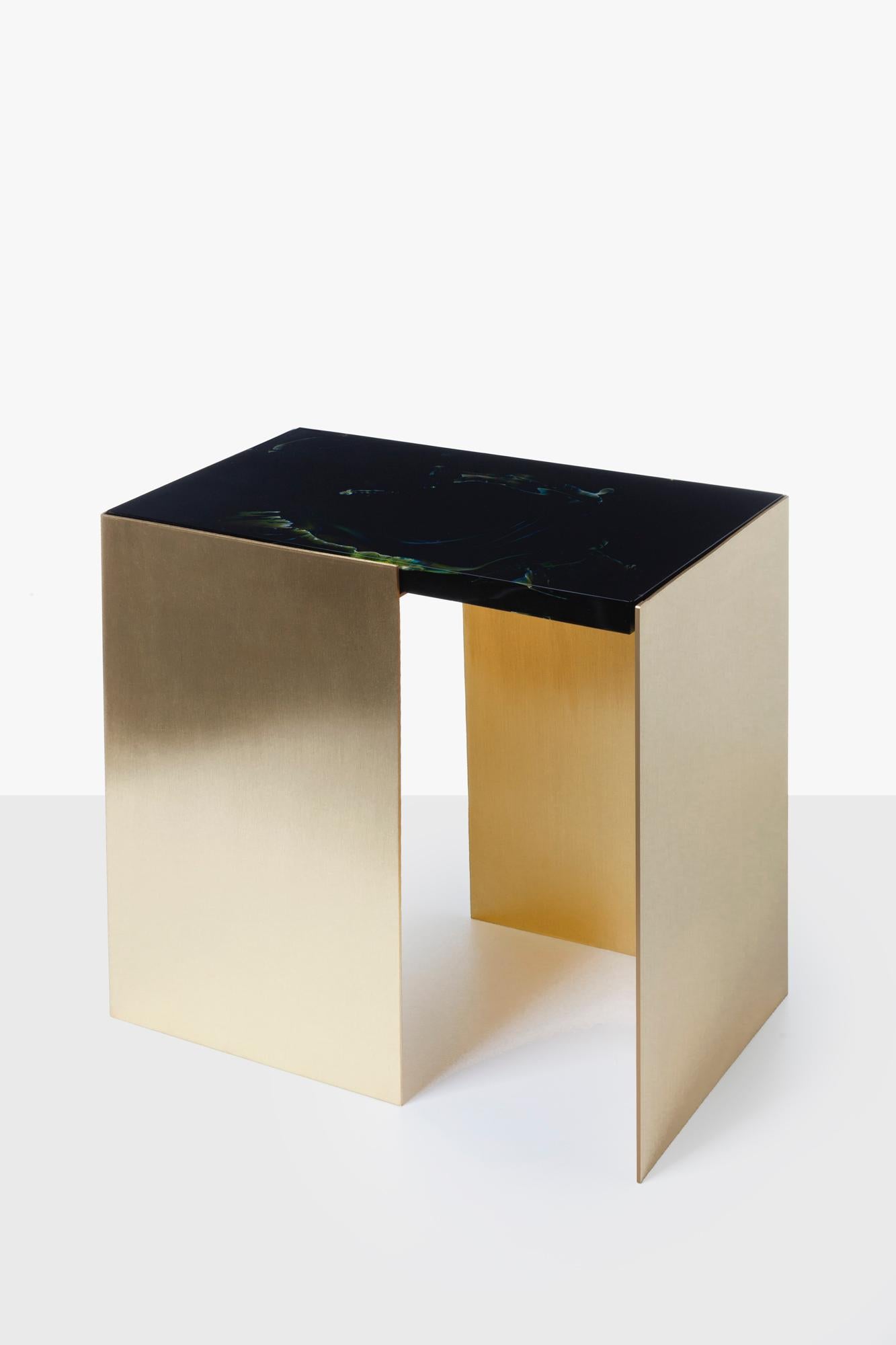 Lithyalin and brass table by Dechem Studio.
Dimensions: D 27 x W 45 x H 45 cm.
Materials: glass, brass.

This simple yet sophisticated coffee table features a minimal geometric construction combined with a marble-like decorative glass top. The