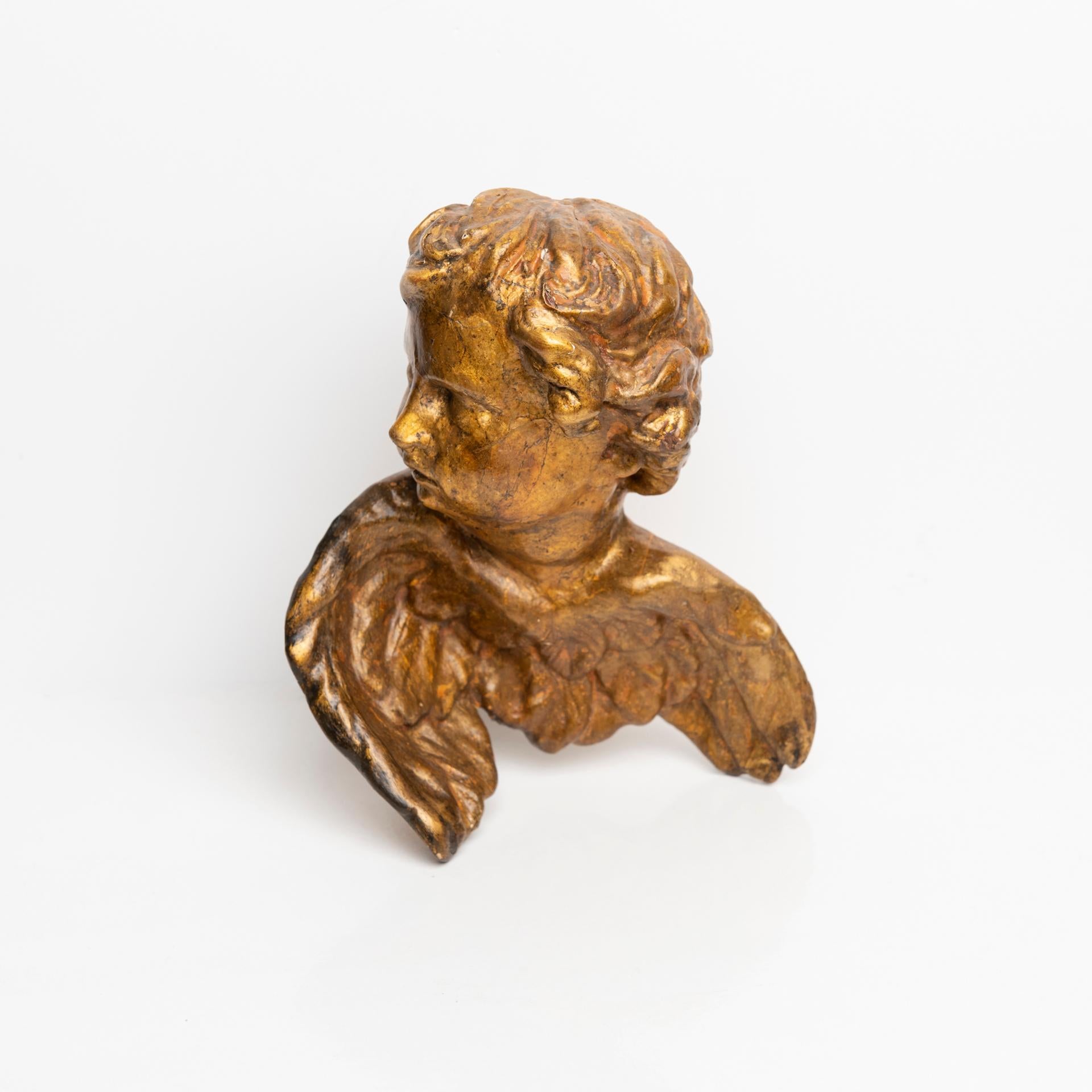 Little angel in gilded wood, with his head turned to the right, as if he were looking at something or someone.
His face has a sweet appearance.

ref. O/7282 -