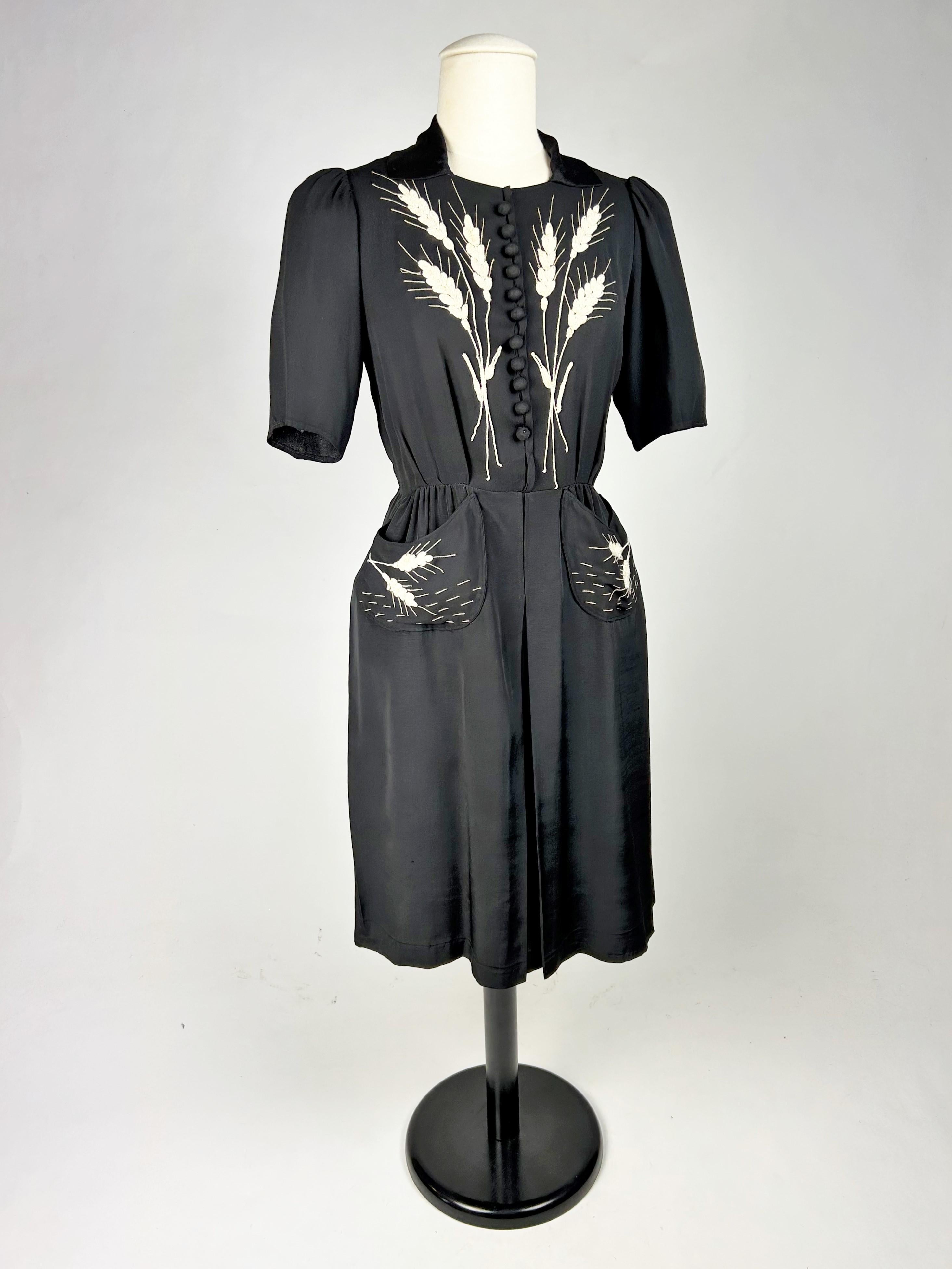 Circa 1943- 1945

France

Interesting little black dress with embroidered white ears of wheat, unmarked and dating from the end of the Second World War. Strapless dress in black crepe, with short sleeves and a small collar with turned-down points.