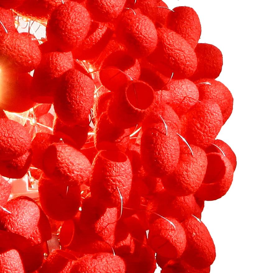 Pequeña Crisálida hecha a mano con capullo de seda en color rojo cereza, un diseño en versión lámpara de sobremesa dentro de la serie clásica que se inició originalmente con la lámpara de pie Chrysalis Sky, está formada por una configuración