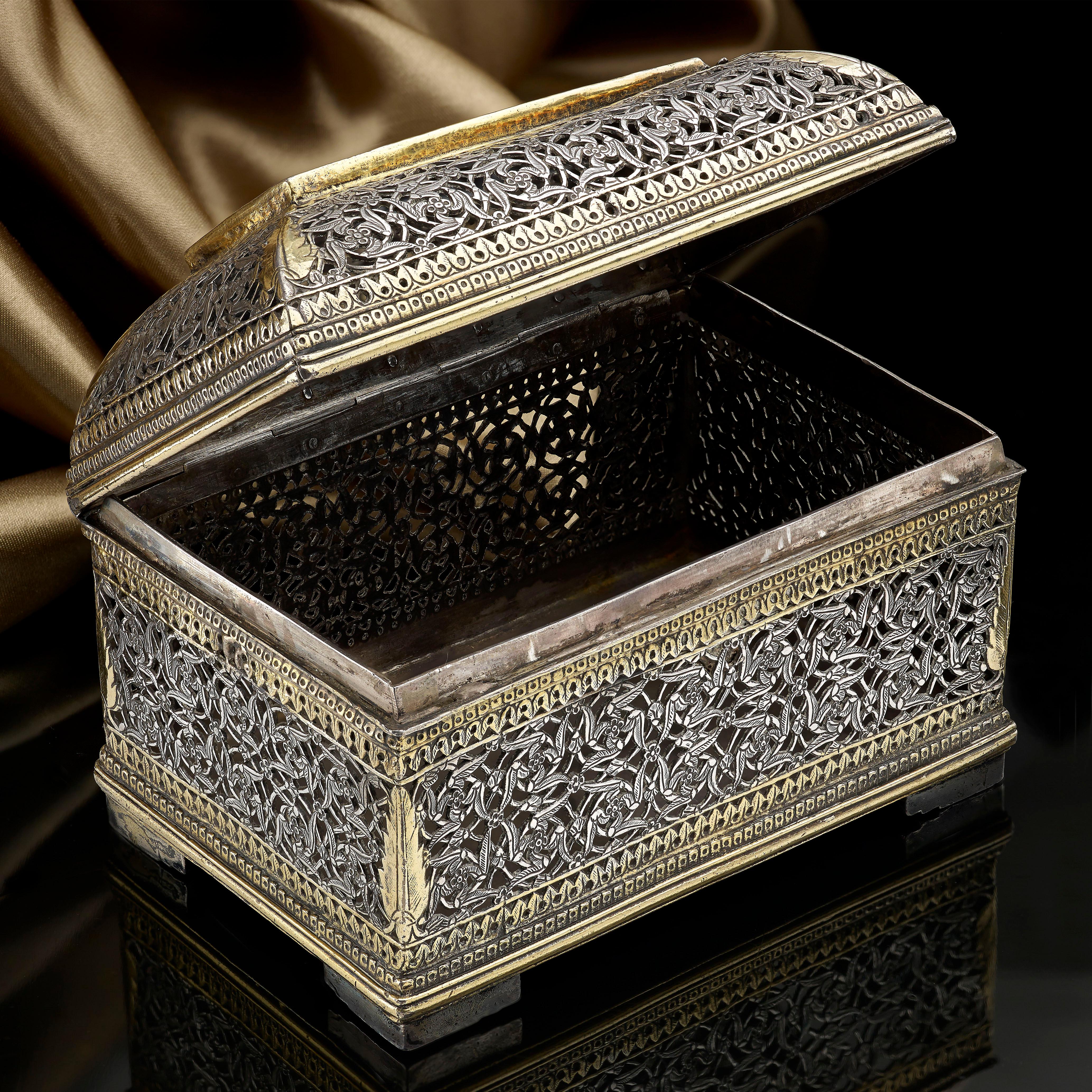 A little Indo–Portuguese silver and parcel gilt box with intricate pierced decoration, late 17th century; approx 4 1/2 inches wide, 3 1/4 inches tall and 3 inches deep. The piece weighs 10 oz approx.