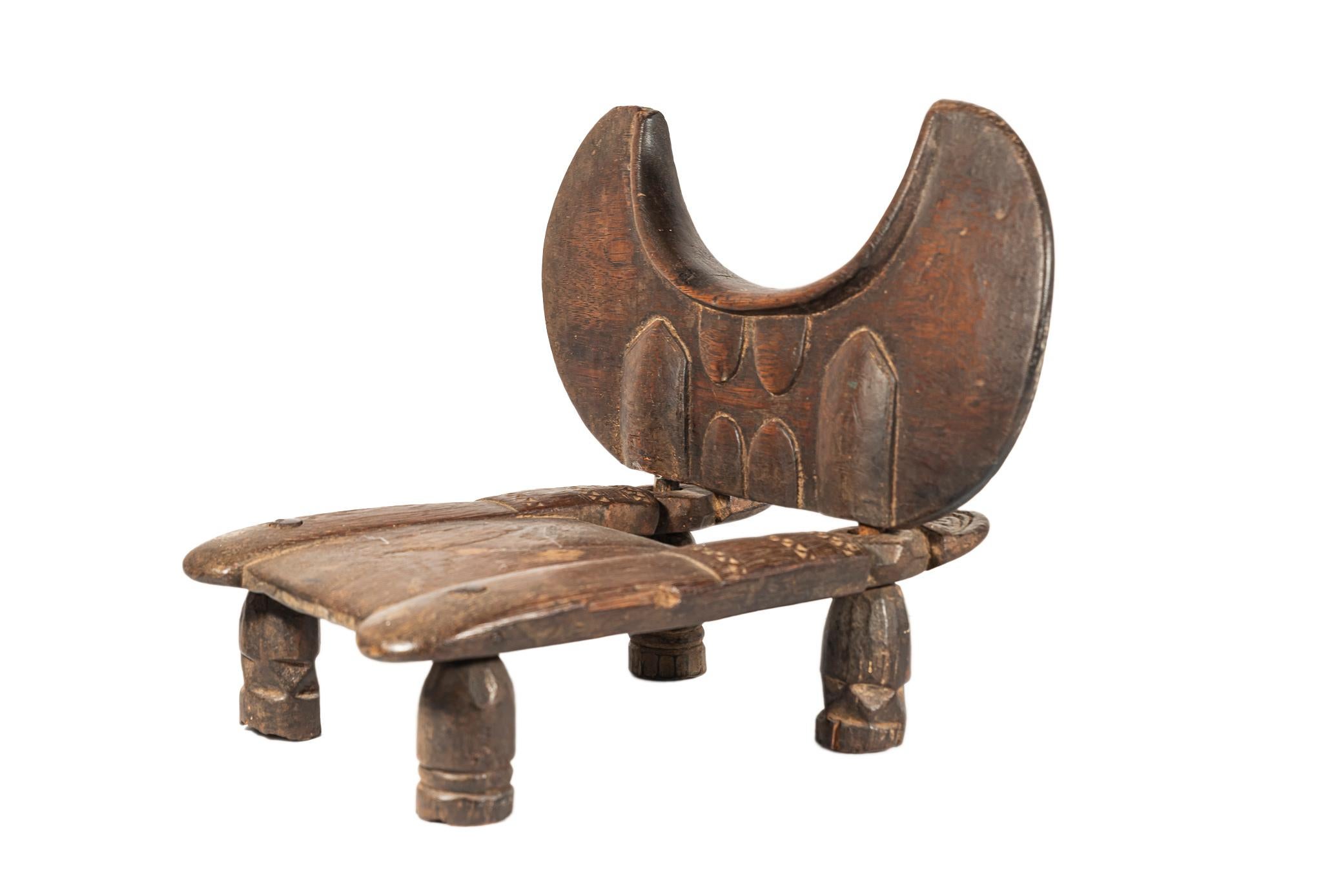 Little Mendé chair, 
Wood, 
The crescent-shaped backrest with carved decorations,
The seat decorated with small carved triangles,
Early 20th century, Sierra Leone. 

Measures: Height 30 cm, seat height 22 cm, width 35 cm, depth 32 cm.

Provenance: