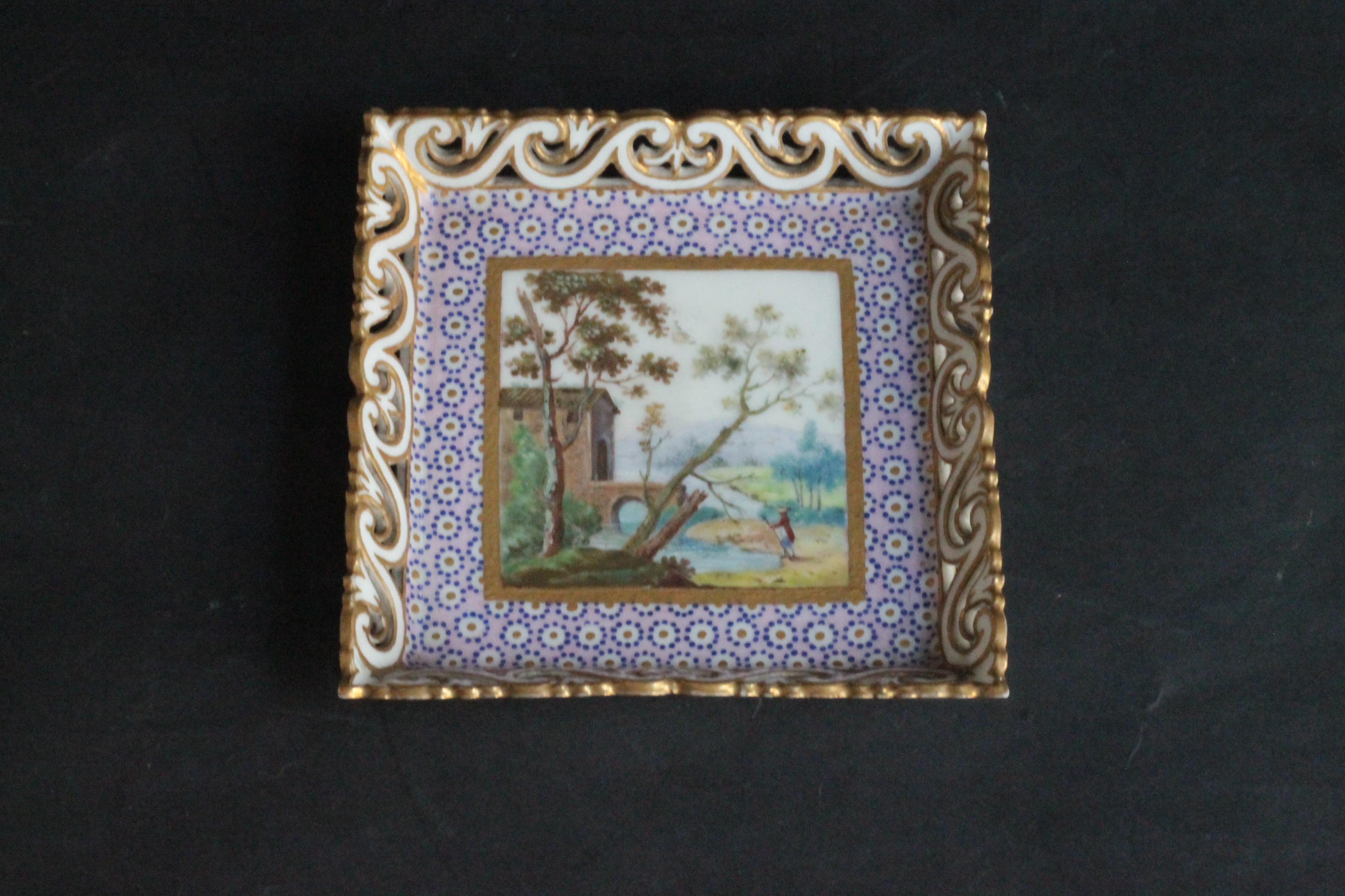 A little square tray (third size) with pierced waves sides in Sevres porcelain decorated with a landscape in the center and ‘oeil de perdrix’ pink ground. Marked with interlaced LL monogram and letter-date M for 1765, 18th century. L x l : 10.5 x