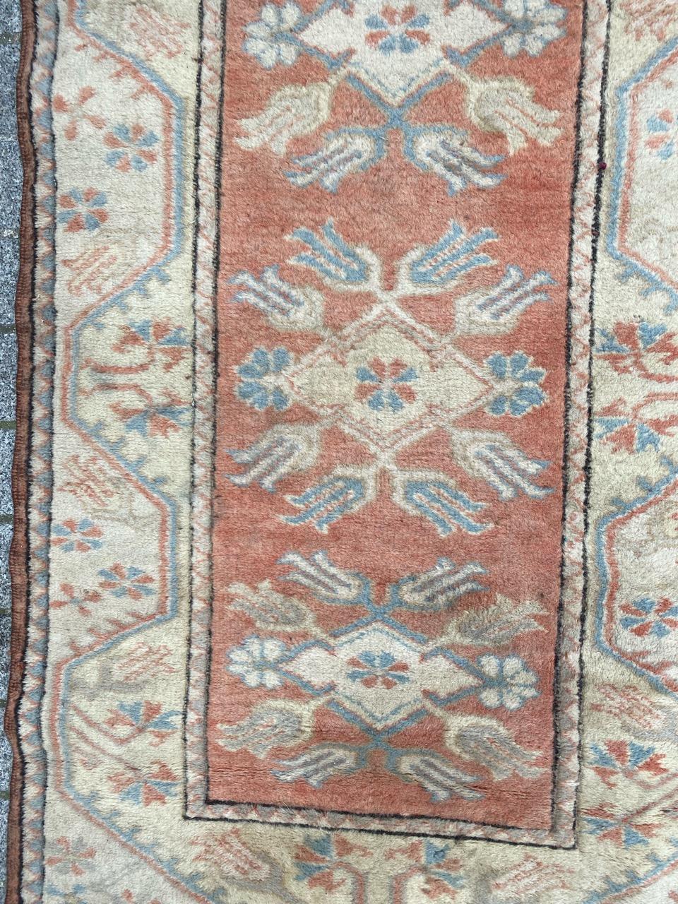 Beautiful small vintage Turkish rug from Kars, meticulously hand-knotted in wool on wool, featuring charming geometric designs. This rug showcases an intricate field pattern with three geometric star-shaped medallions in beige and subtle blue