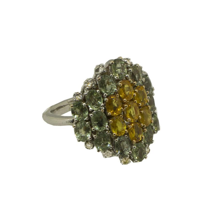 Elegante anello di moda in oro bianco 14K con struttura composta da un fiore di zaffiri gialli al centro circondato da zaffiri verdi tutt'intorno. È impreziosito da piccoli diamanti bianchi 
Diamanti 0,22 ct 
Zaffiri verdi e gialli 5,81 carati 
Peso