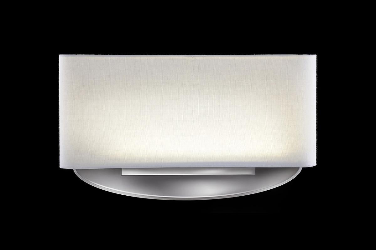 Low profile eggshell fabric shade with cast aluminum holder and backplate. In the manner of streamline moderne. LED lamping, standard color temperature 3000k.

Architect, Sandy Littman of Duesenberg LTD. and The American Glass Light Company have
