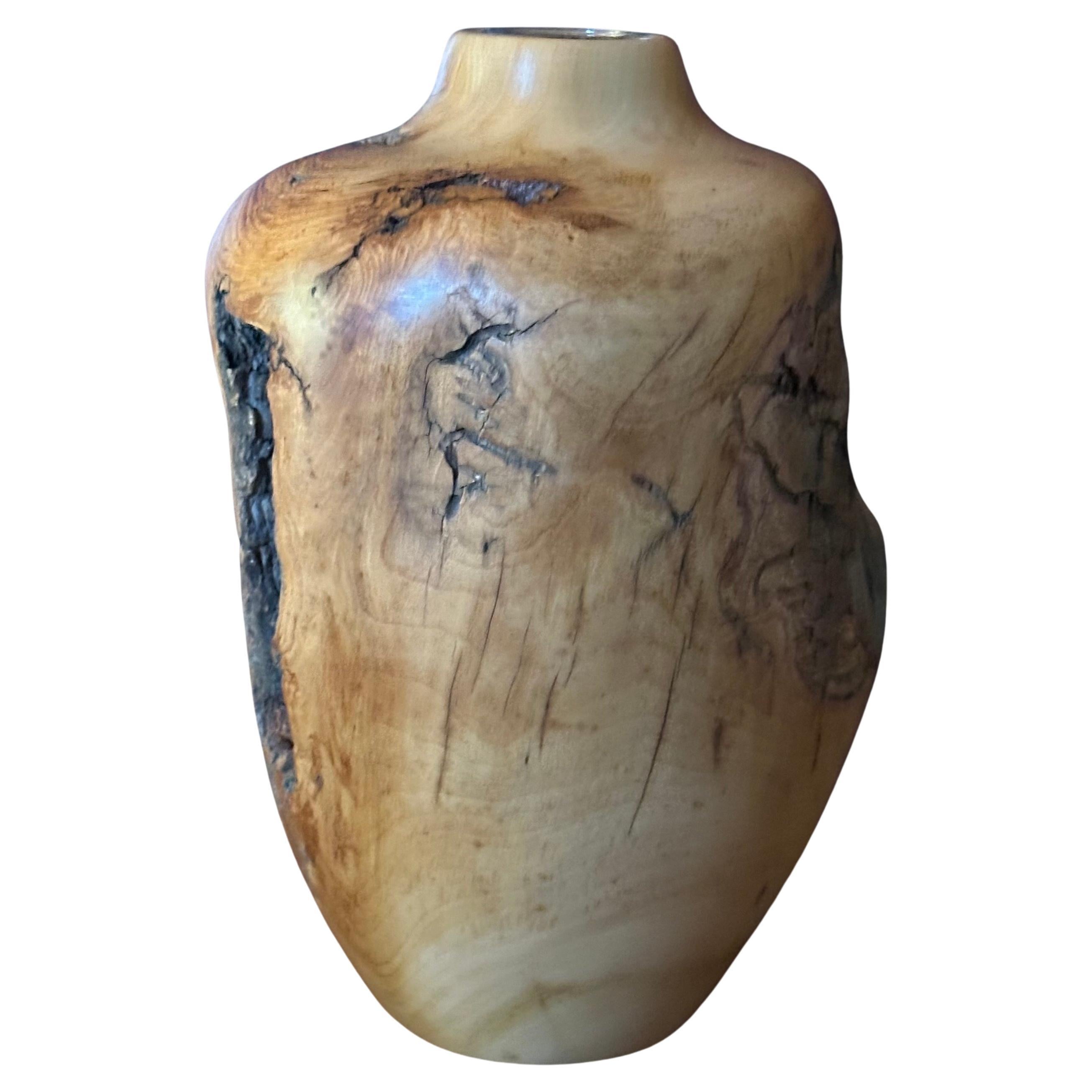 An unusual live edge Aspen burl wood vase with glass insert, circa 2001. The piece is in very good condition, measures 7.75