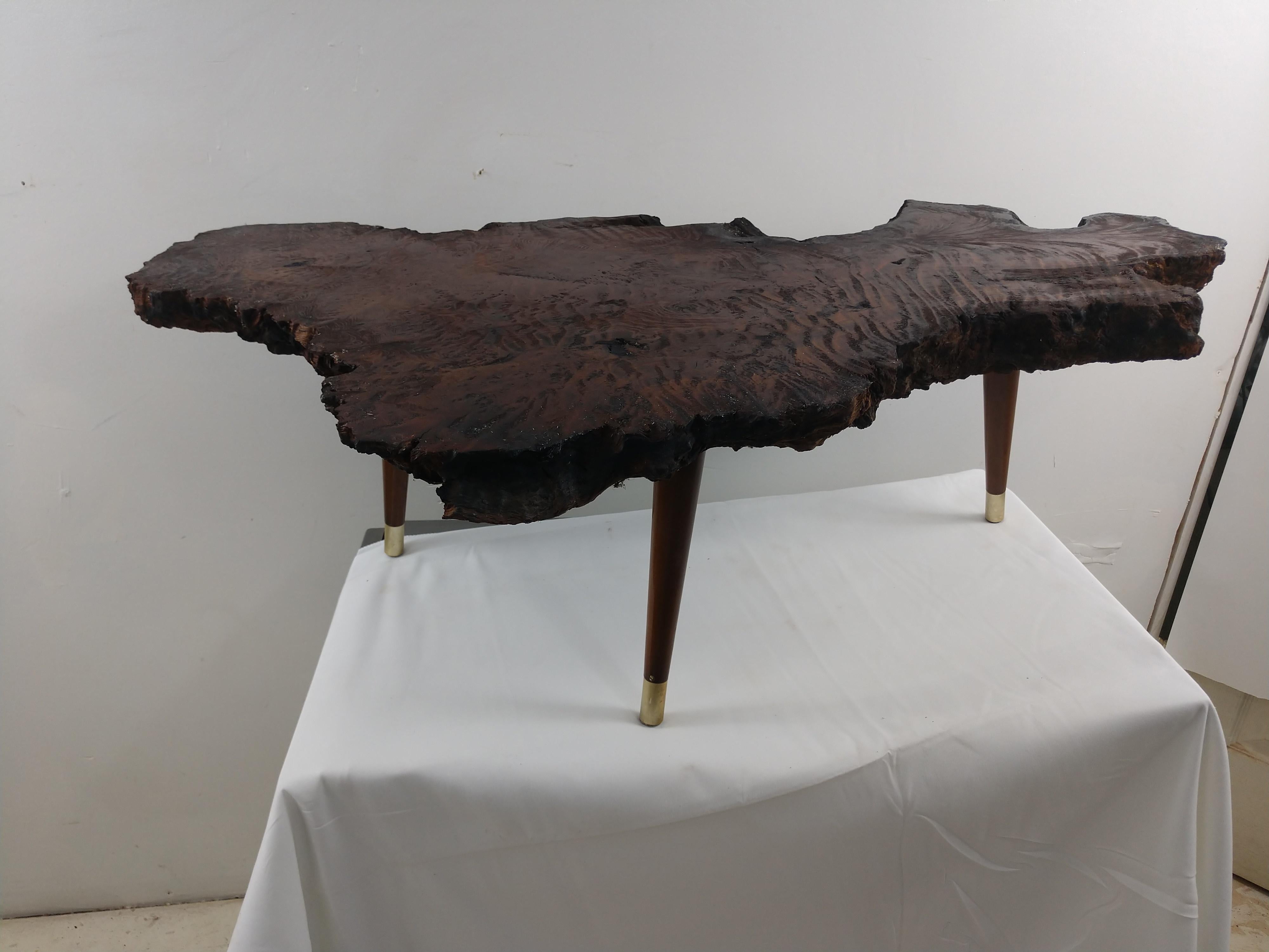 Amazing slab of burled Maple. Freeform style that was coated with teak oil for protection, then waxed with a paste wax. Thick slice of the base, root approx. 2.5 inches thick. Fabulous grain. Three 1960s style tapered walnut legs with brass sabots.