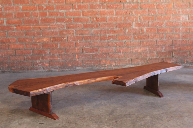 A vintage 1960s solid walnut live egde coffee table in the style of George Nakashima. In excellent original condition. The live edge walnut top sits on two live edge legs with angled feet.