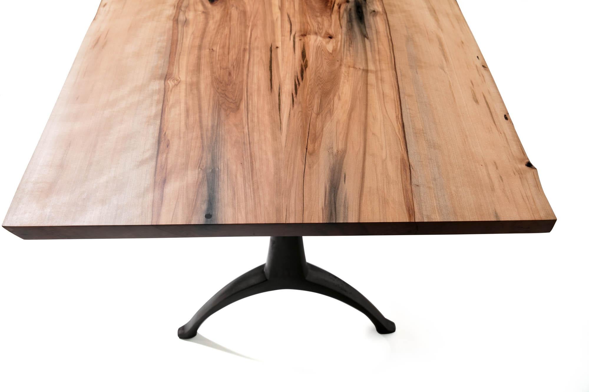 Our live edge dining table features the natural curves of this item's original form, a living tree! This beautiful piece of woodworking sits atop our iron Legacy Wishbone Base, hand designed and cast at Sloss Furnaces National Historic Landmark in