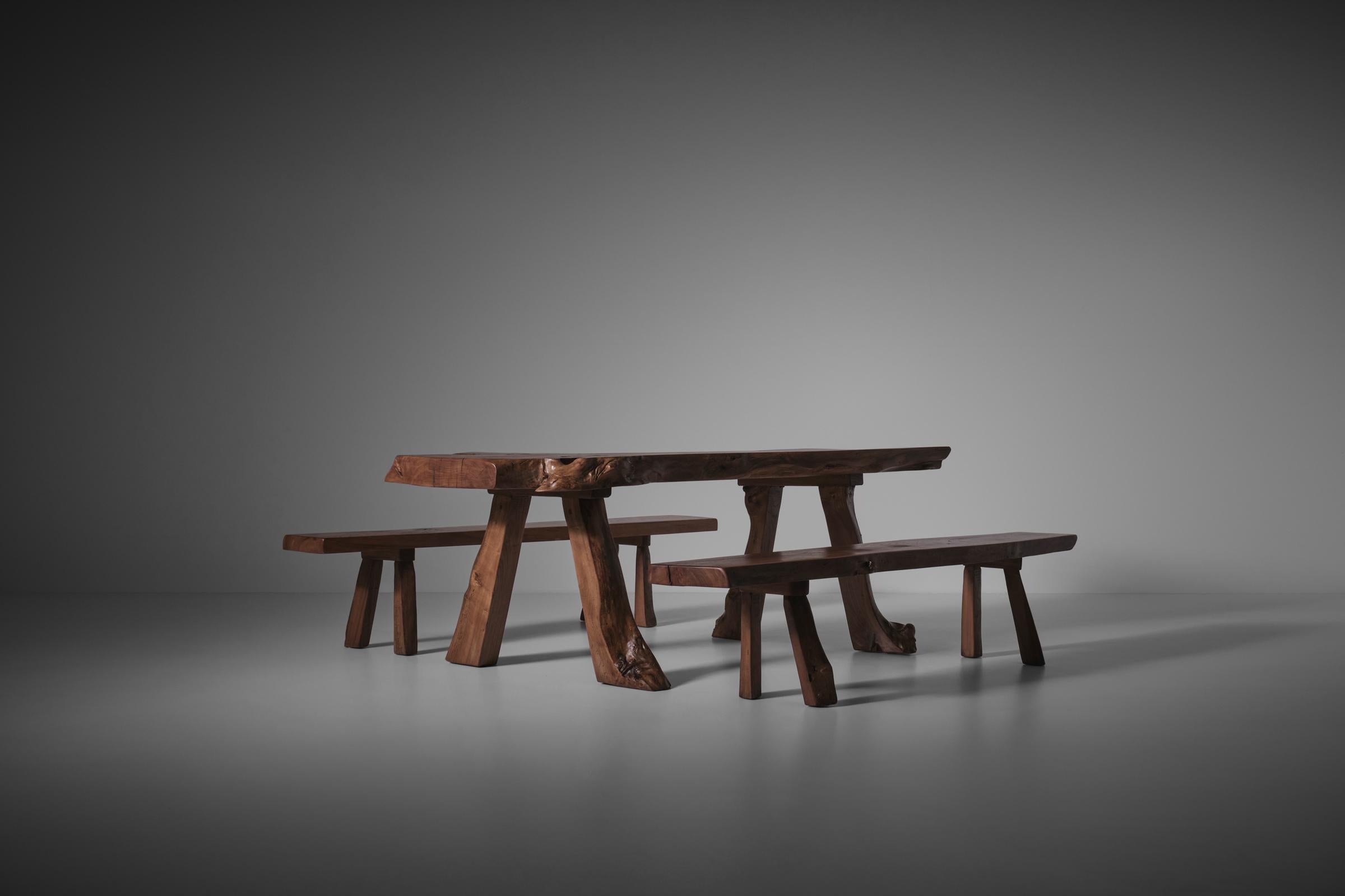 Elm wooden dining table and benches, France 1970s. Unique piece made in the 1970s by a woodworker in the South of France from old Elm wood, locally sourced in the forest. Very sculptural yet brutalist appearance. The wood is showing some amazing