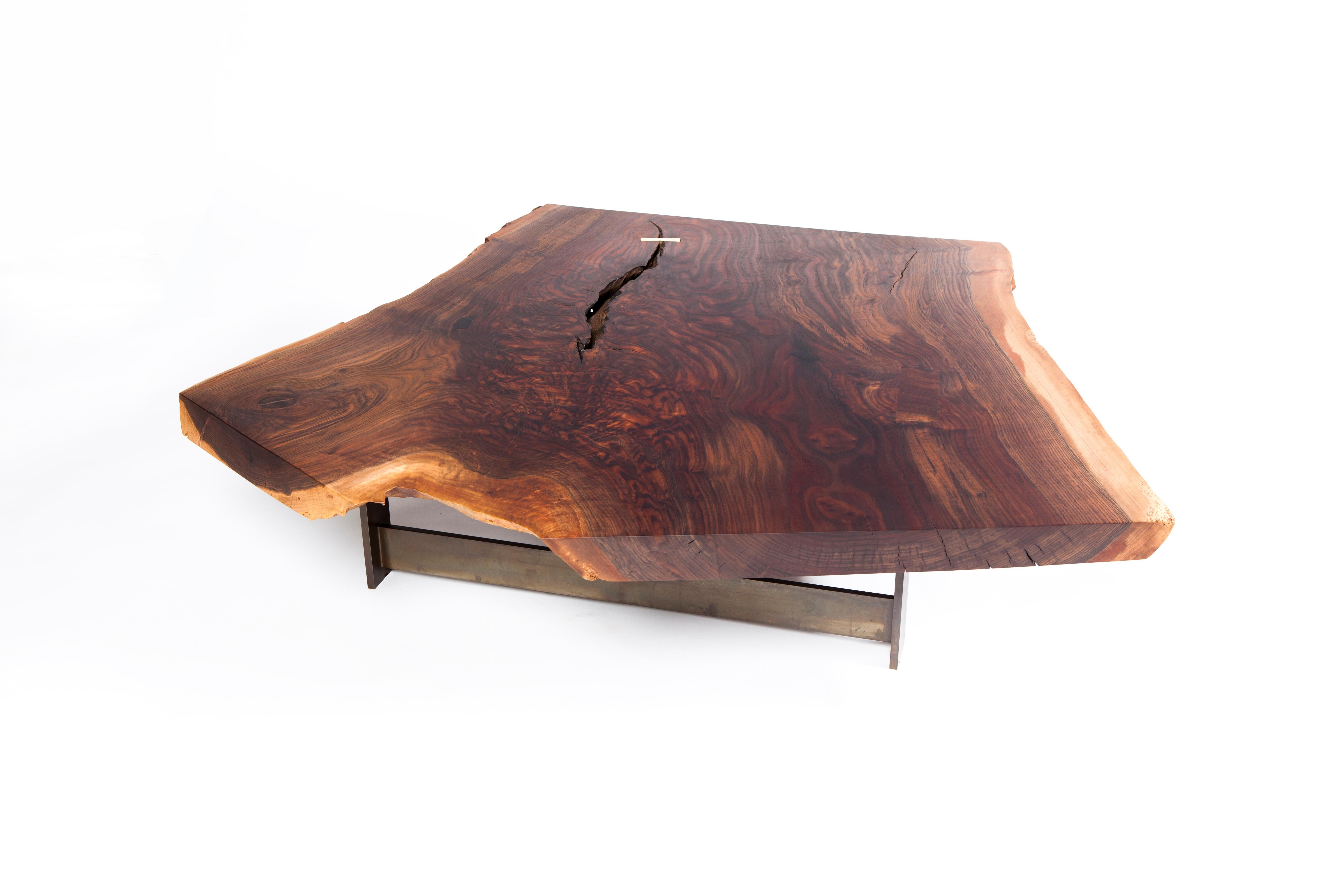 The graft coffee table by Taylor Donsker features a live edge California Claro Walnut Y-slab top which rests on his signature patinated steel T base, making the slab appear to float from certain angles. Taylor added a polished brass butterfly key to