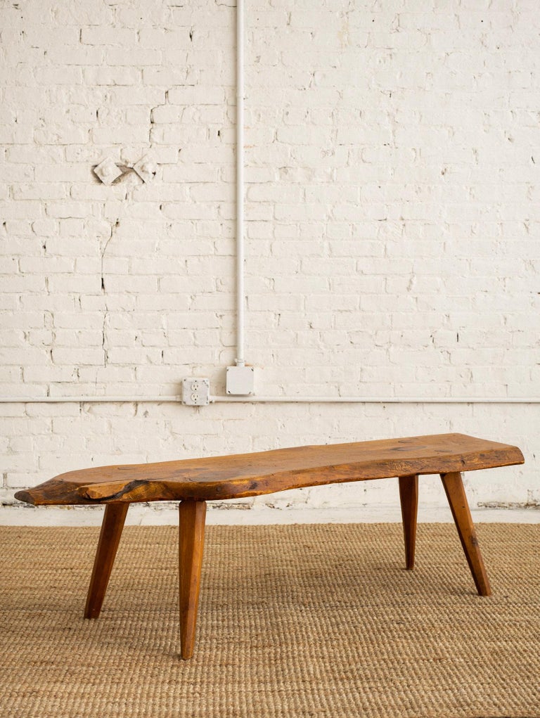 Rustic studio made live edge coffee table. Knotty pine slab on tapered legs. Butterfly joint detail.