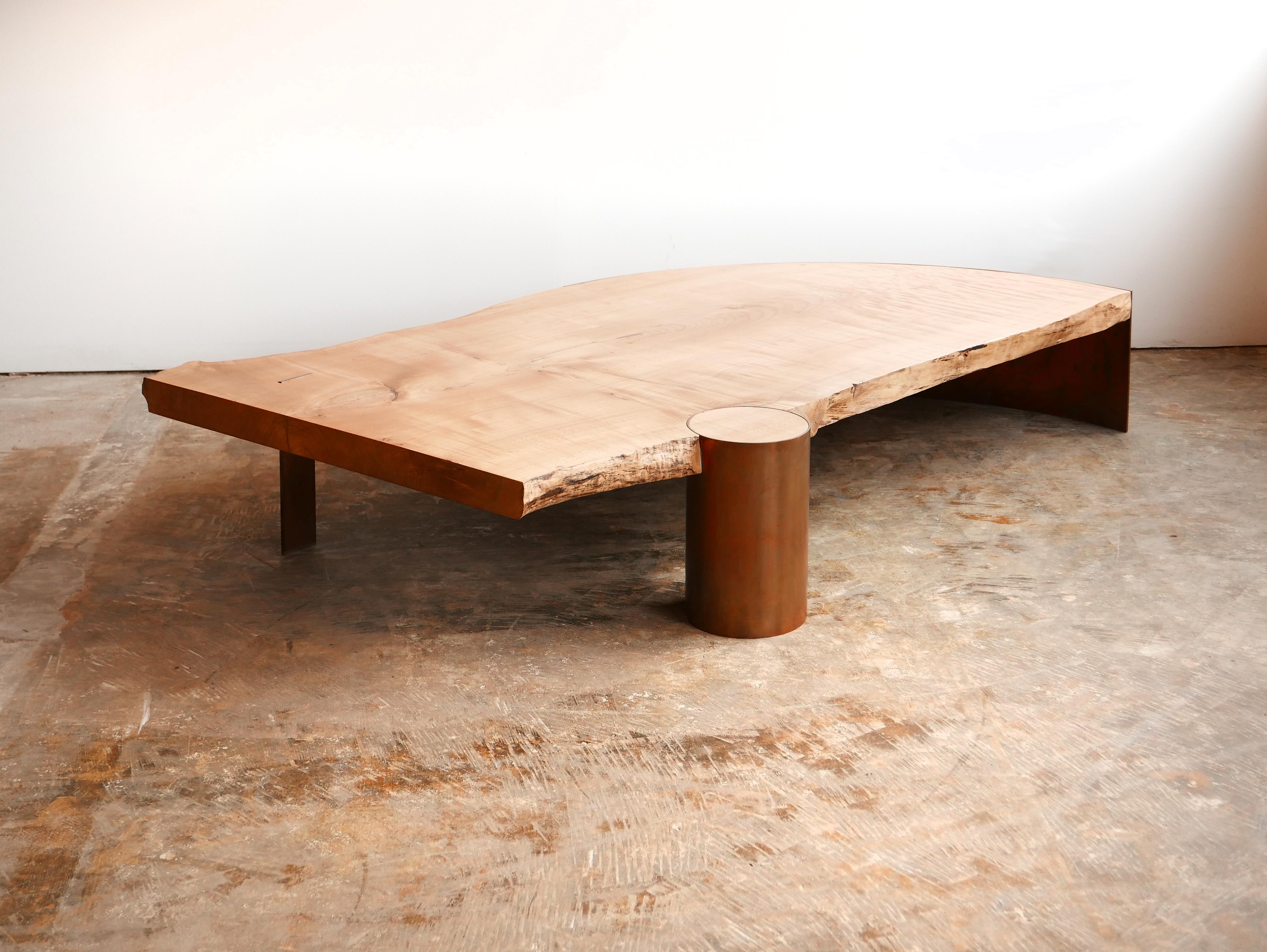 Cette magnifique table basse en érable massif est unique en raison des trois pieds en cuivre qui la soutiennent.  Une extrémité est maintenue par une feuille incurvée d'acier cuivré de 1/4