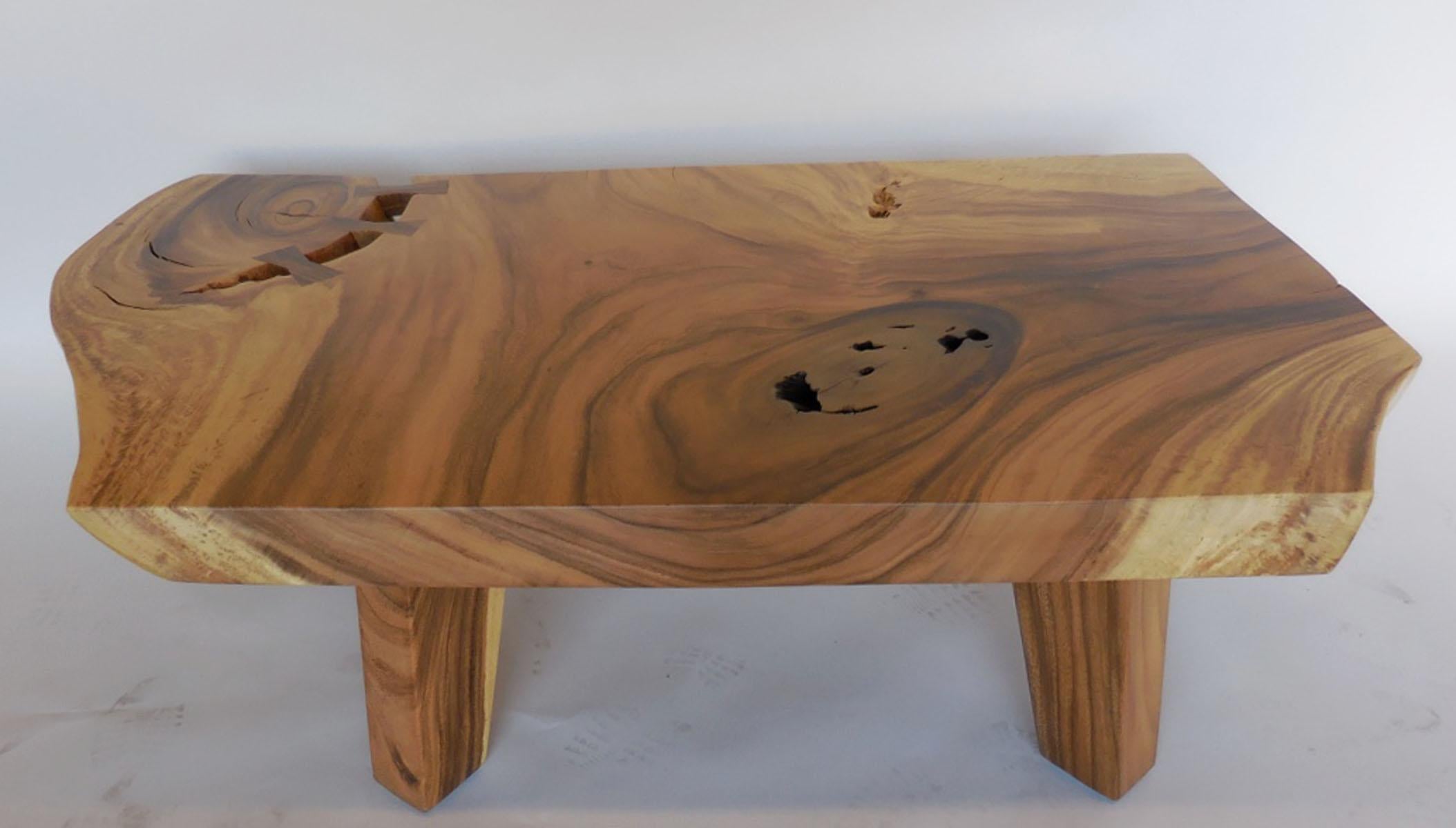 Beautiful Albezia wood table. The top is a one wide board, sagittally cut and solid top measuring 3.5 inches thick and has a live, undulating edge. The natural crevice of a knot is accentuated with three wooden mariposas (butterflies).
The graining