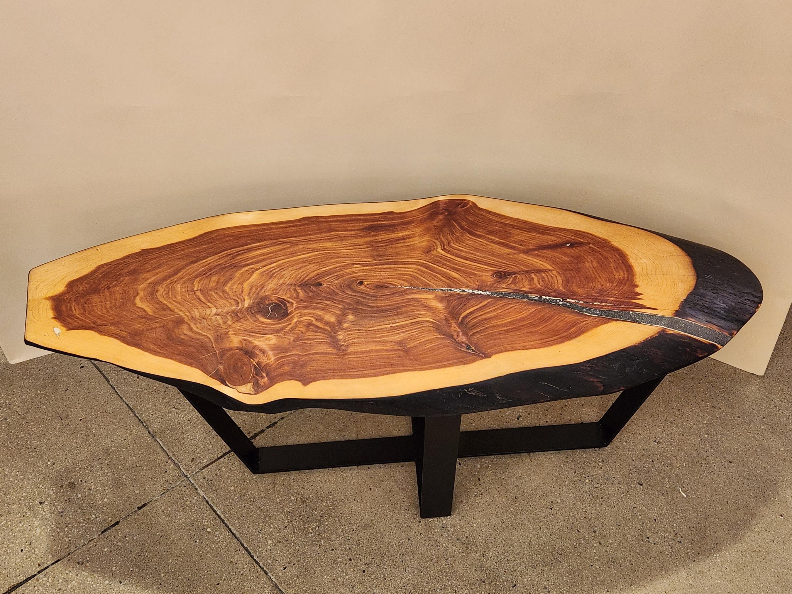This cookie slab coffee table is a unique piece that is both functional and artisanal and offers an eye catching display.
 
 It was designed by Creation Therrien. It is made from red cedar wood with a crack that was filled with a quartz and