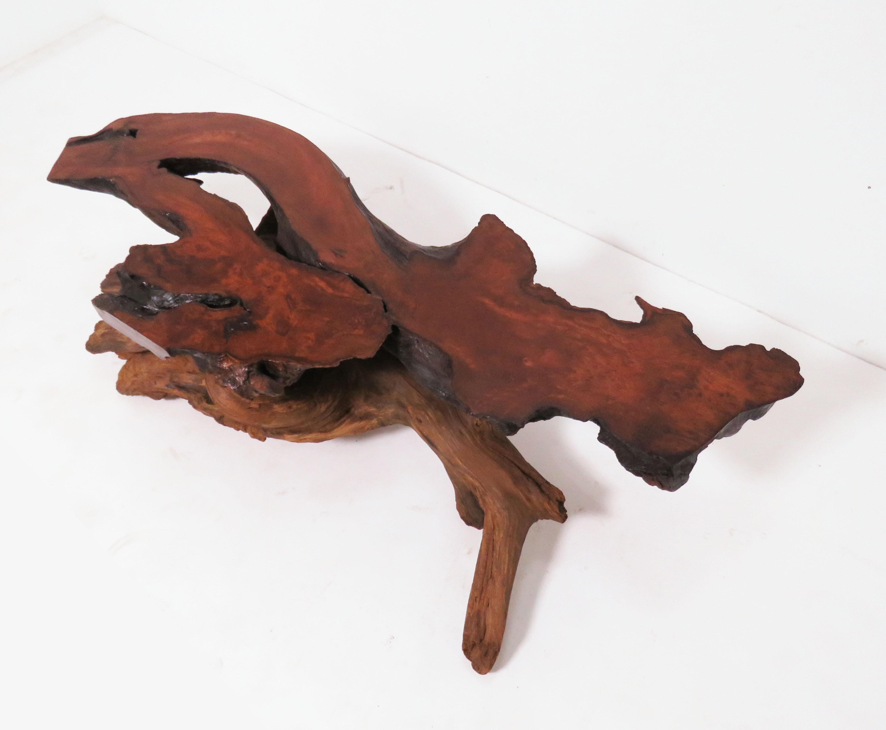 A California modernist coffee table, circa early 1970s, in the manner of and most likely by the noted furniture artisan and sculptor Daryl Stokes. A common signature element of Stoke’s work was his contrasting use of raw driftwood shards of redwood