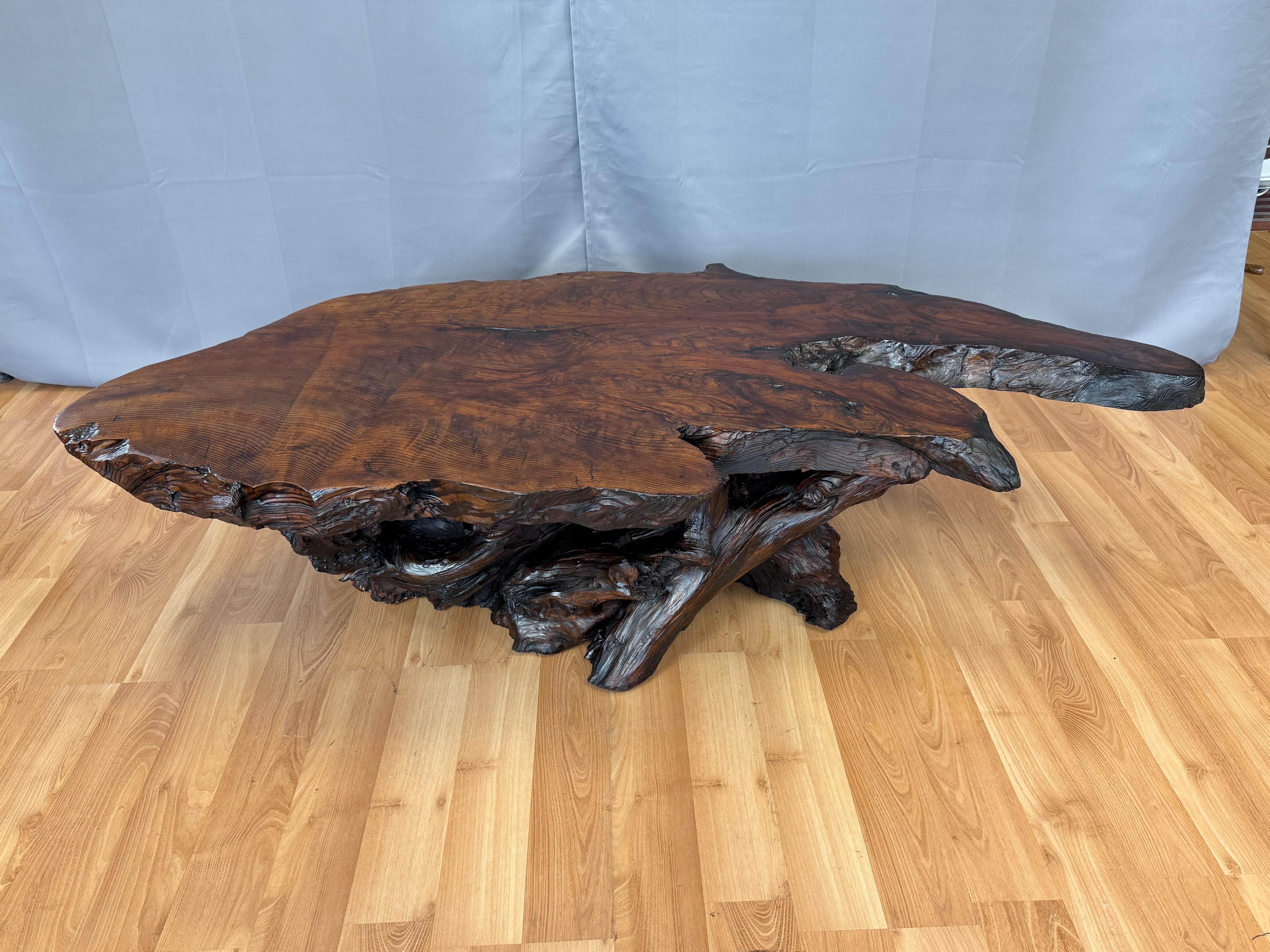 An exceptionally handsome and well-crafted circa 1970 live edge California redwood burl slab coffee table with redwood limb and root base.

Expansive two-and-a-half-inch-thick old growth redwood burl slab top with a striking shape and fantastic
