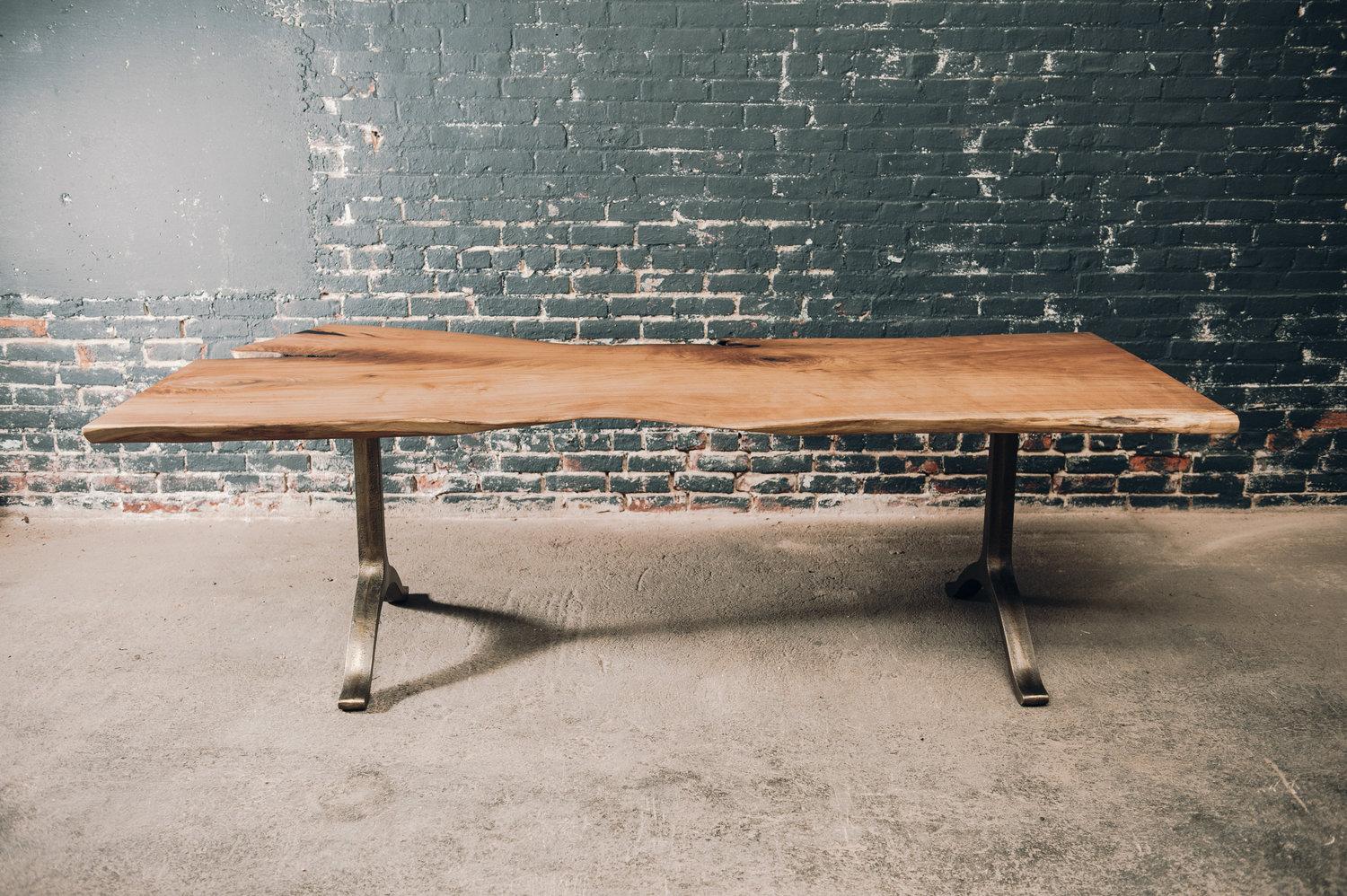 The top of this table is a single slab that has been finished with a protective oil/wax natural finish. We left the natural voids to add depth to this piece and keep the natural elements alive. The bronze plated double thick wishbones carry this