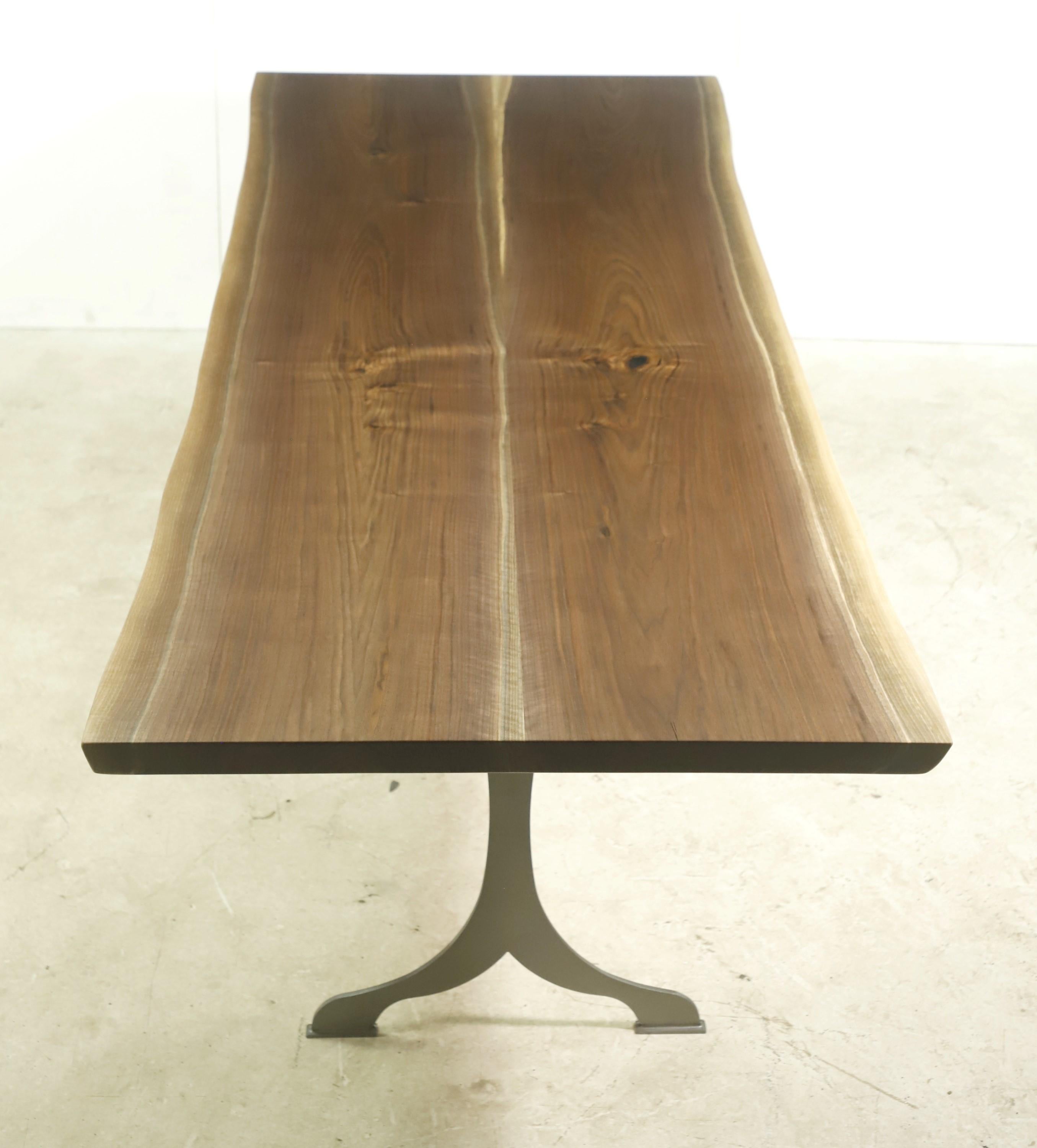 This live edge table features a two slab solid walnut top with a satin finish paired with brushed steel wishbone legs. This table is ready to ship. Please note, this item is located in our Scranton, PA location.