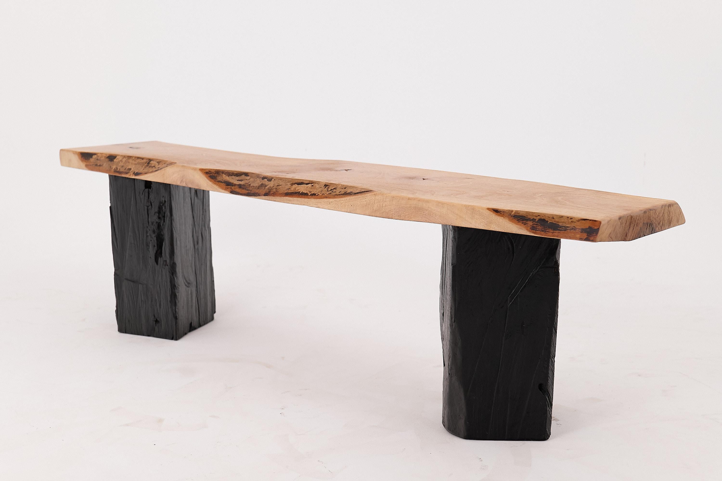 Minimalismus und Natur treffen sich in dieser eleganten Bank von Logniture, die vollständig aus massivem Hartholz gefertigt ist. Der Sitz behält die natürlichen Wellen und Kanten des Baumes bei und hebt die fließende Maserung und die Tonvariationen