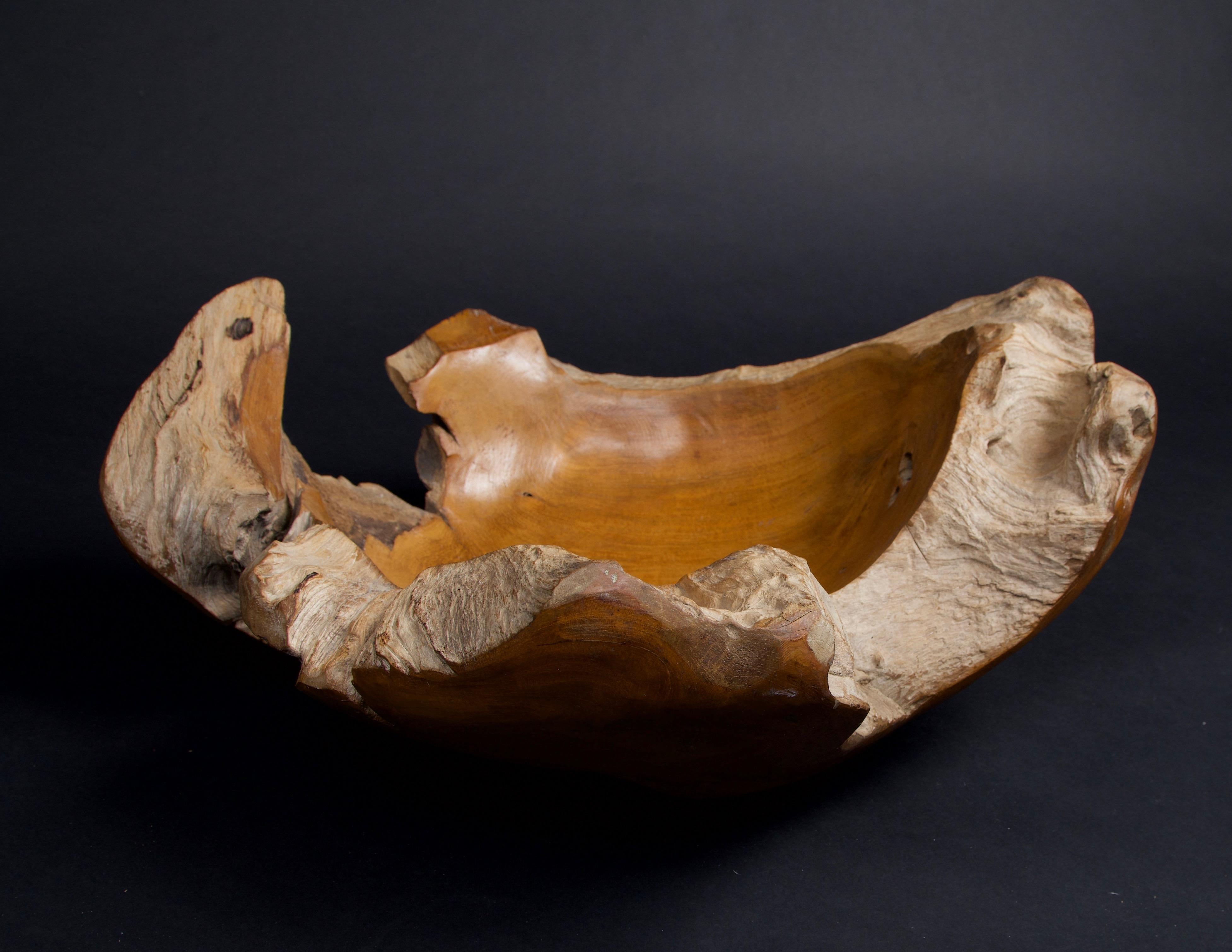 This bowl is hand carved from a teak root, leaving the live edge to give the bowl a unique organic shape. The inside and the outside of the bowl is waxed to give a smooth finish while the rim of the bowl is left untouched to preserve the natural