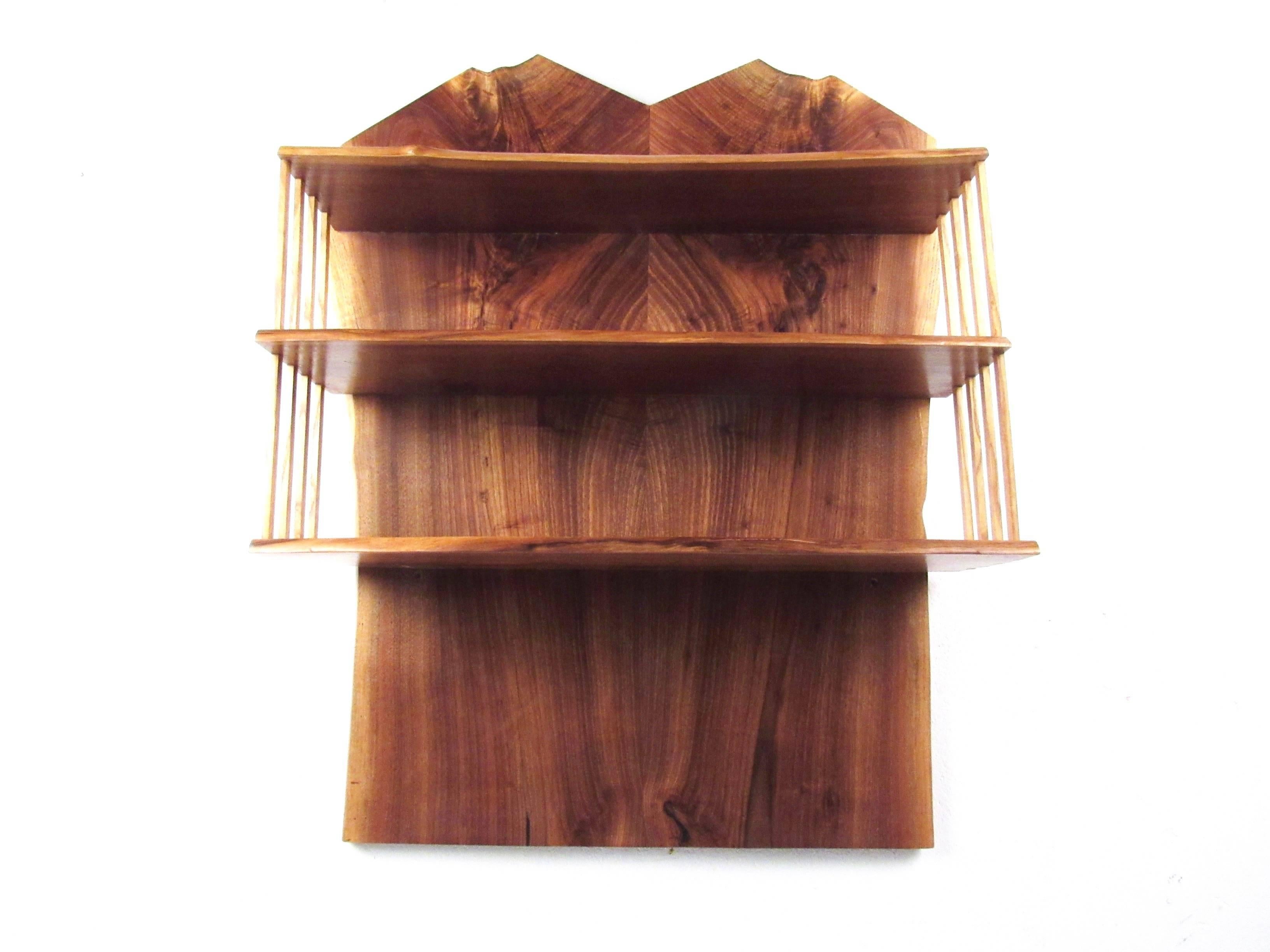 This impressive handmade wall shelf features rich hardwood construction with beautiful wood grain and rustic live edge design. Three shelves for ample storage, this George Nakashima style shelf makes an eye-catching display piece for home or