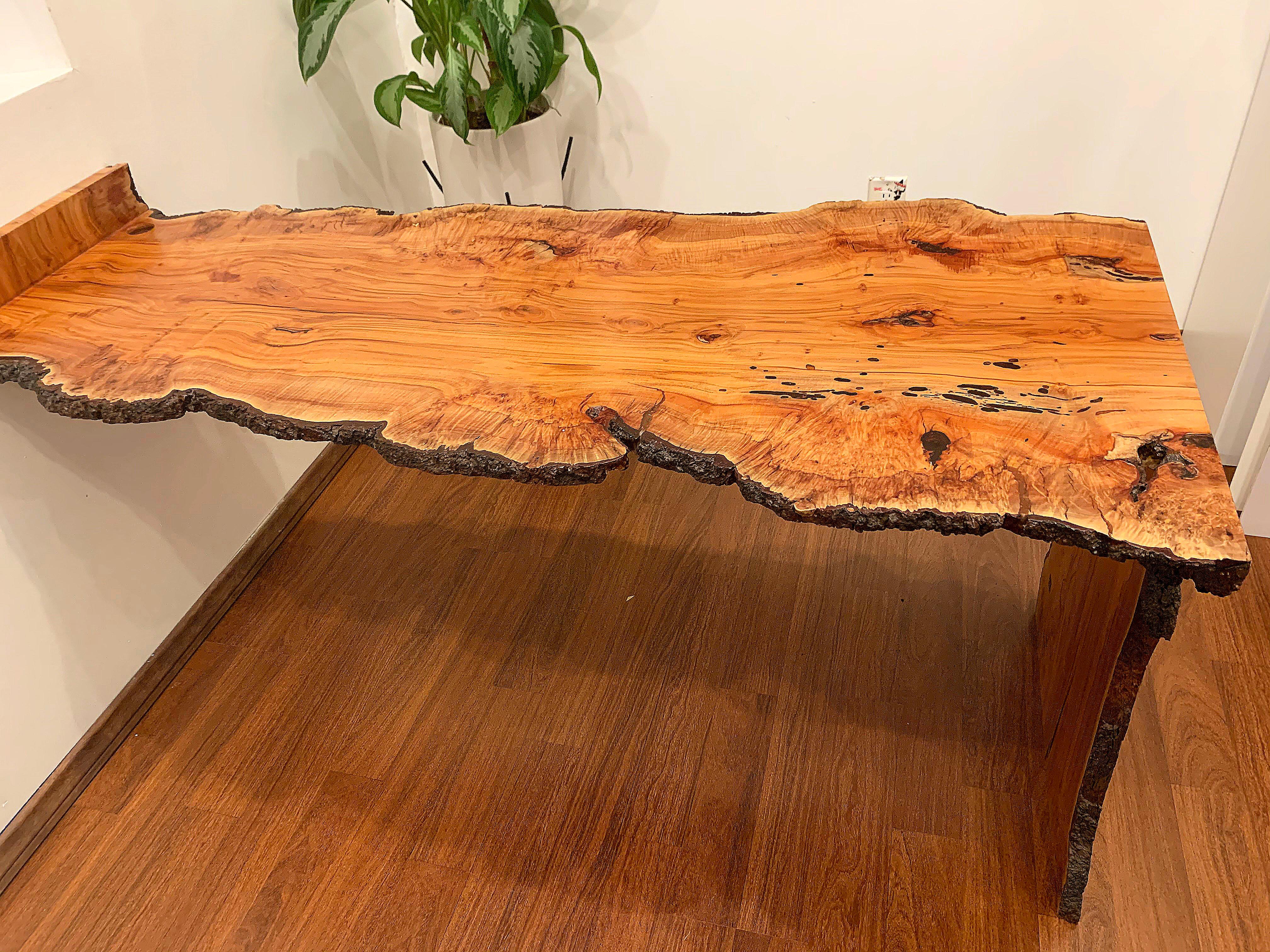 Burl wood live edge waterfall desk by San Diego designer. Although it isn't heavy, the desk should be suspended with wall anchors or other reinforcement.

Waterfall 29 inches
Width of desk at waterfall 24.5 inches
Width of desk at middle is 23.5