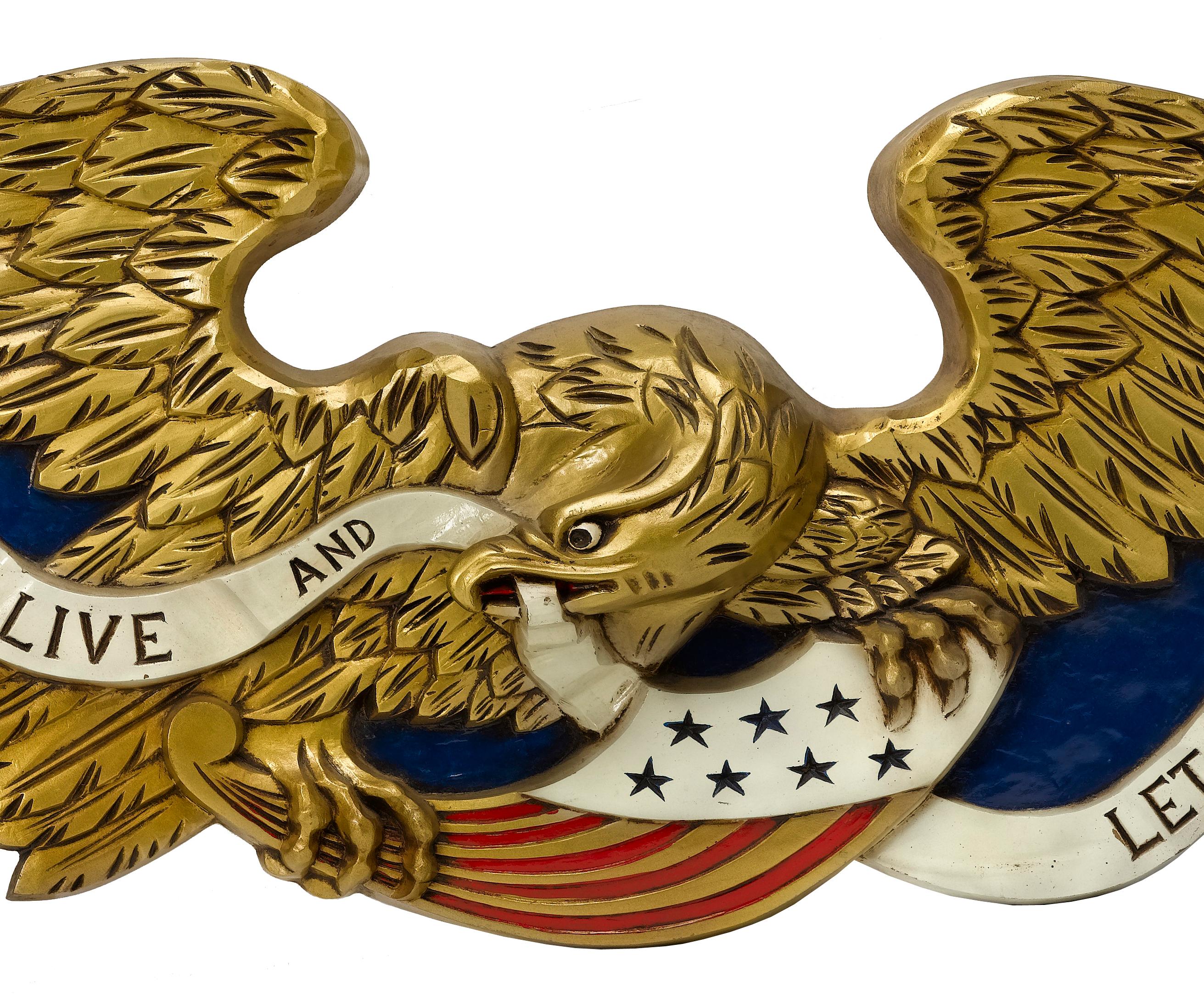 Offered is a stunning, hand carved and hand painted eagle. The eagle is depicted in mid flight, with both wings widely extended. The eagle holds a ribbon in its beak, which reads 