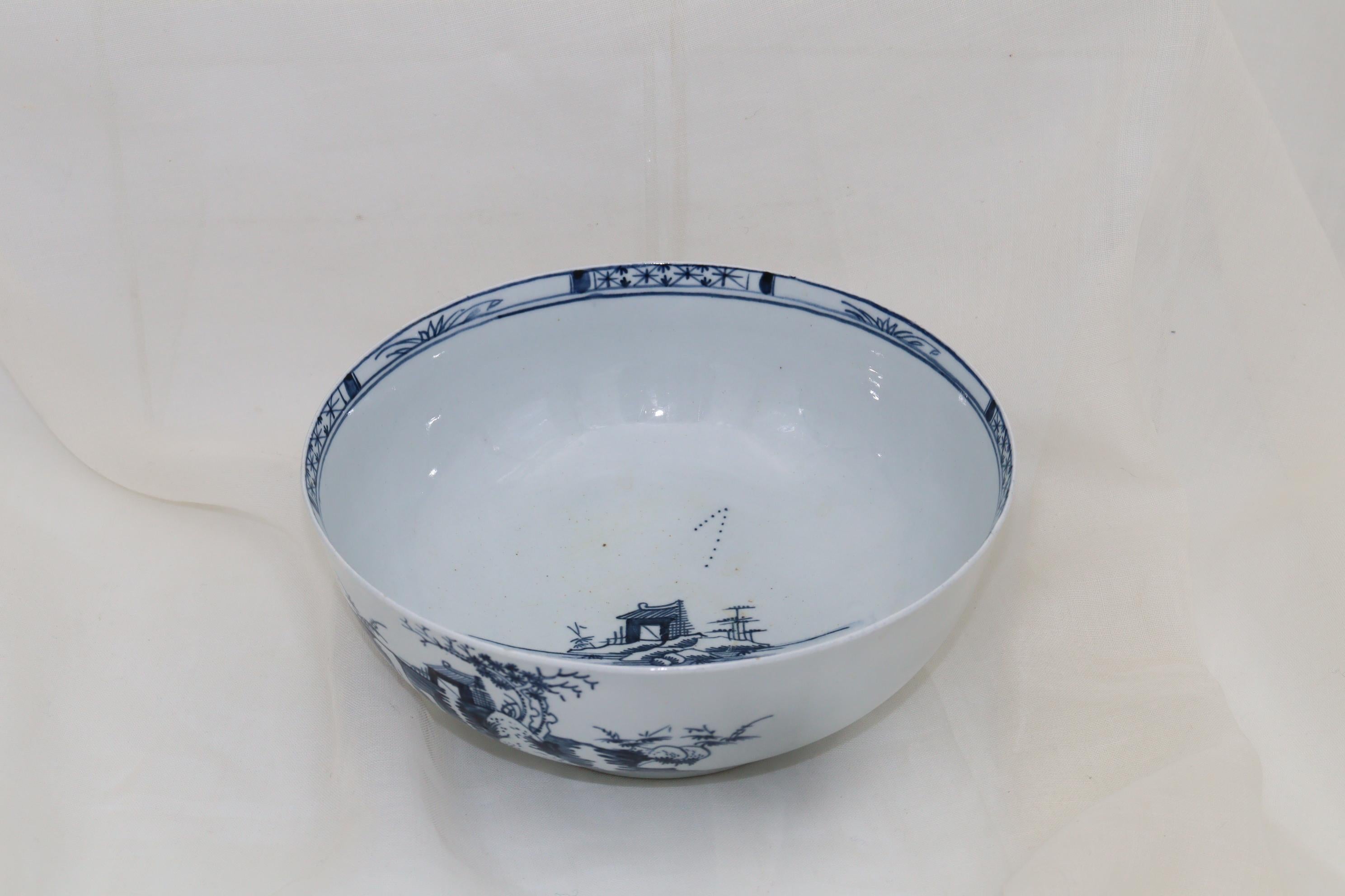 This Liverpool porcelain bowl is decorated on both sides and to the centre with a hand painted Chinoiserie style blue and white landscape. Probably a small punch bowl, it measures 189 mm (7.75 inches) in diameter and stands 80 mm (3 1/8th inches)