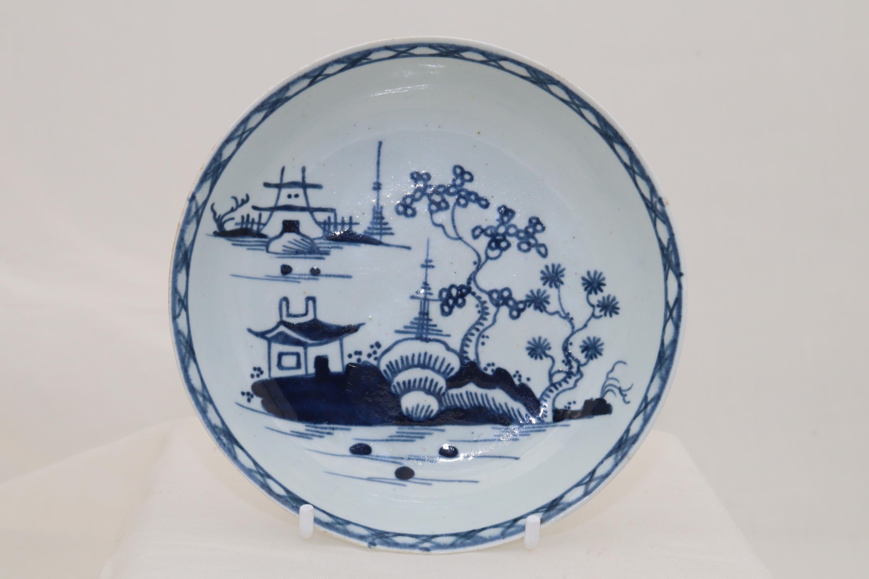 This Liverpool porcelain tea bowl and saucer is decorated with the hand painted 