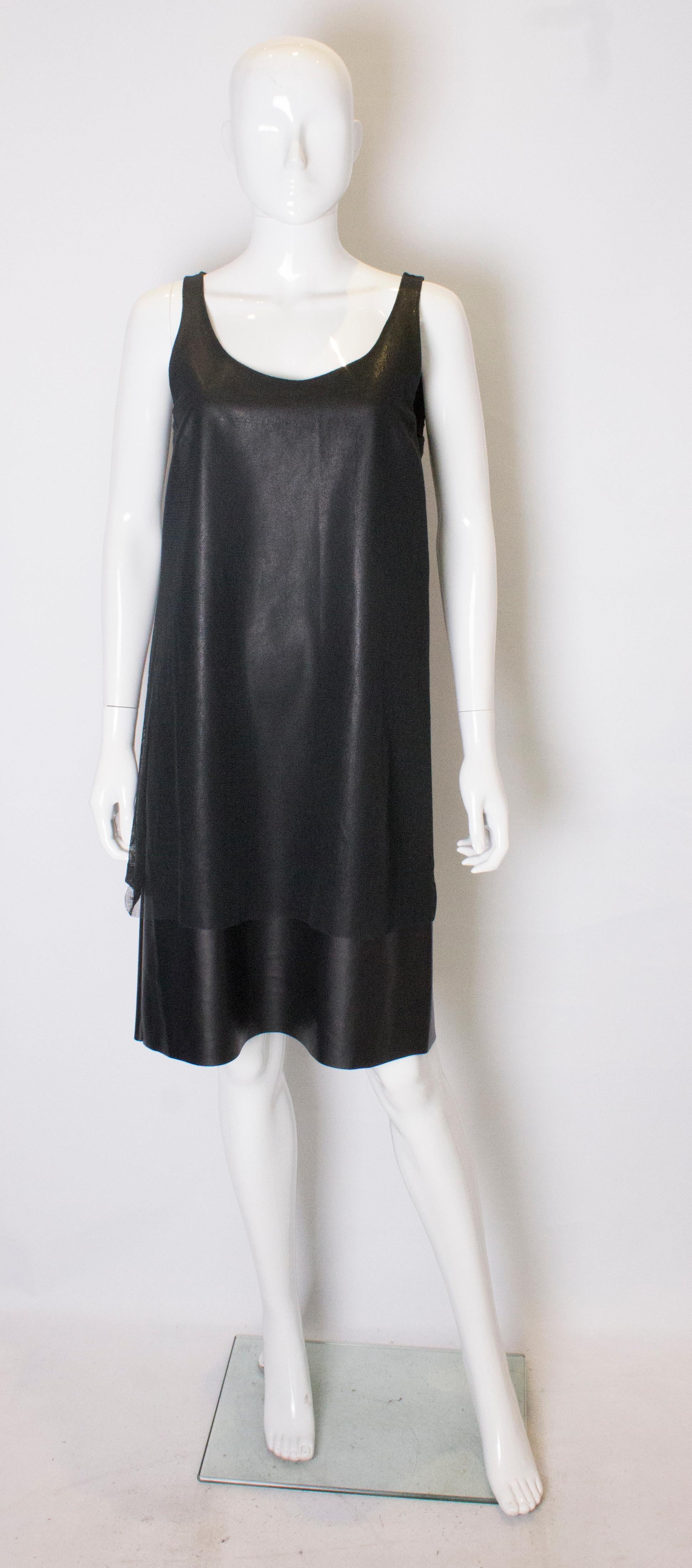 A chic shift dress by Liviana Conti. The dress has  a low round neckline, with black net over the pvc underdress.