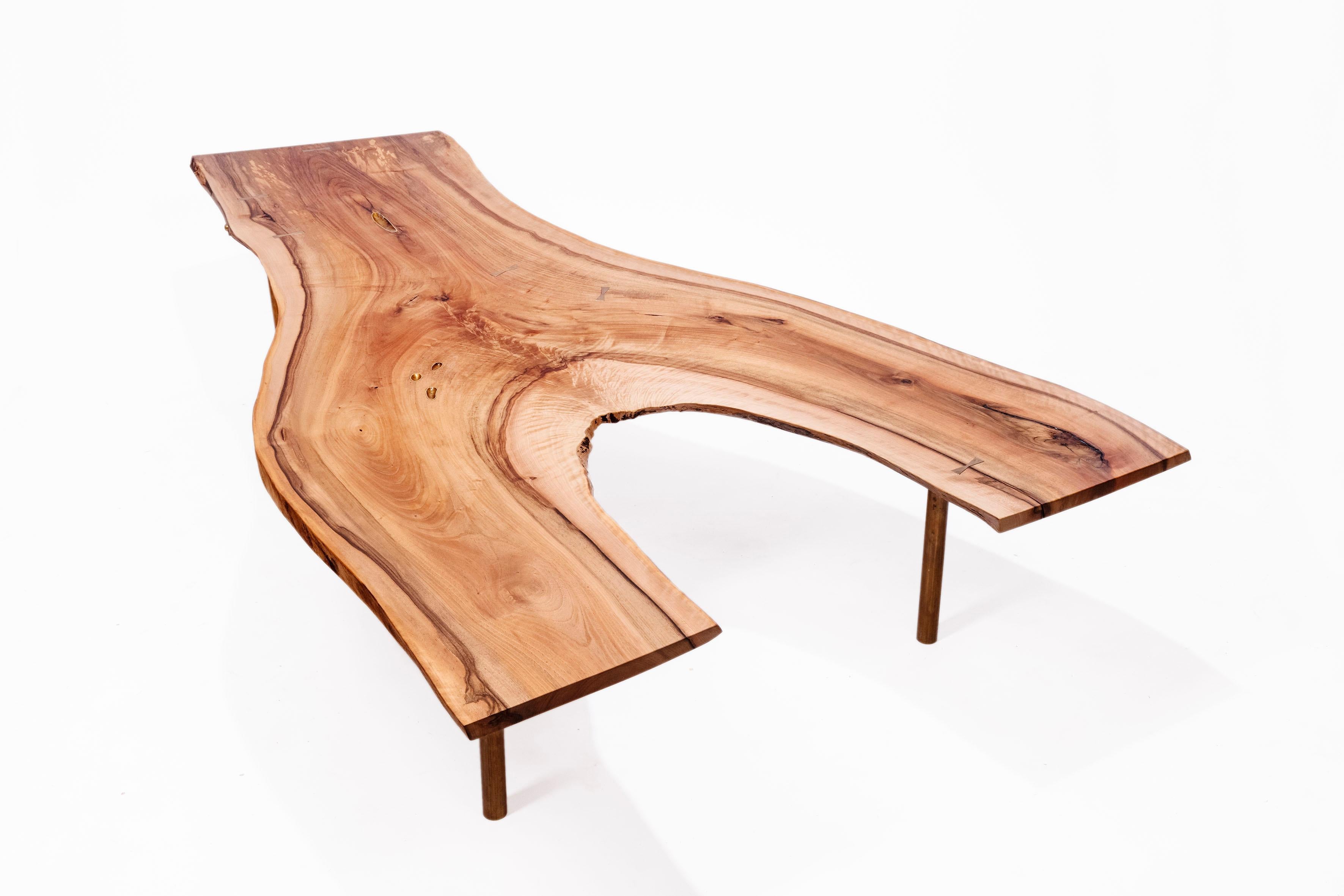 Eccentrically shaped out-branching living-edge table from Laura Bergsøe, In Danish walnut, with brass details and brass signature spike. The frame are in iron, and table legs are in brass.

Measurements:
Length (199 cm)
Width (55 - 115